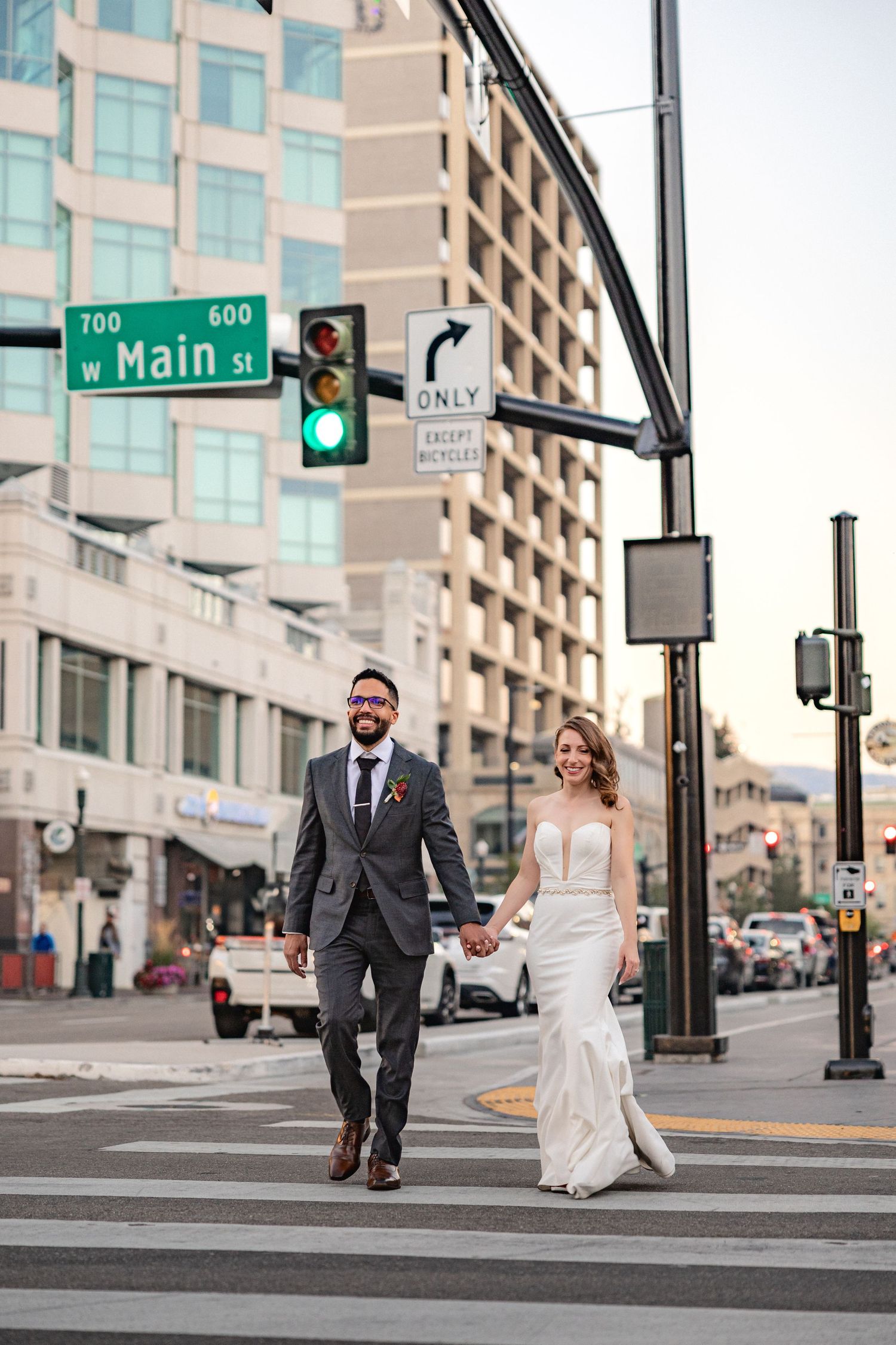 A couple in wedding attire crossing Main Street in downtown Boise.