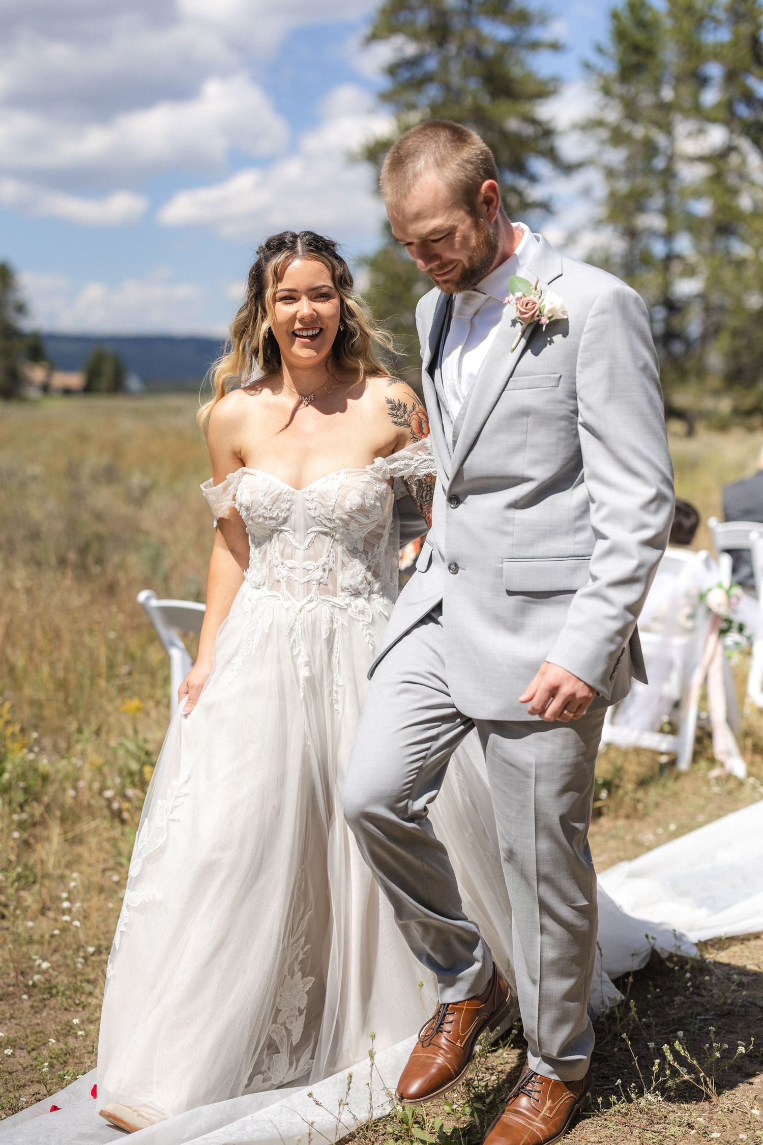 Happy couple sharing joyful moment on their wedding day in scenic mountain setting.