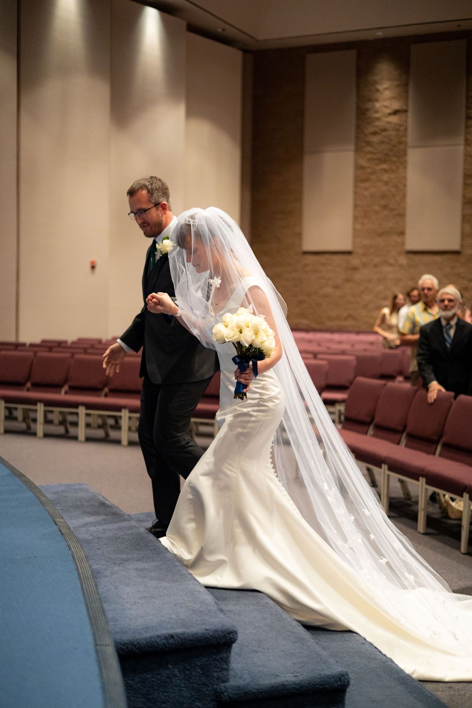Wedding ceremony participants sharing a solemn moment in prayer at church altar.