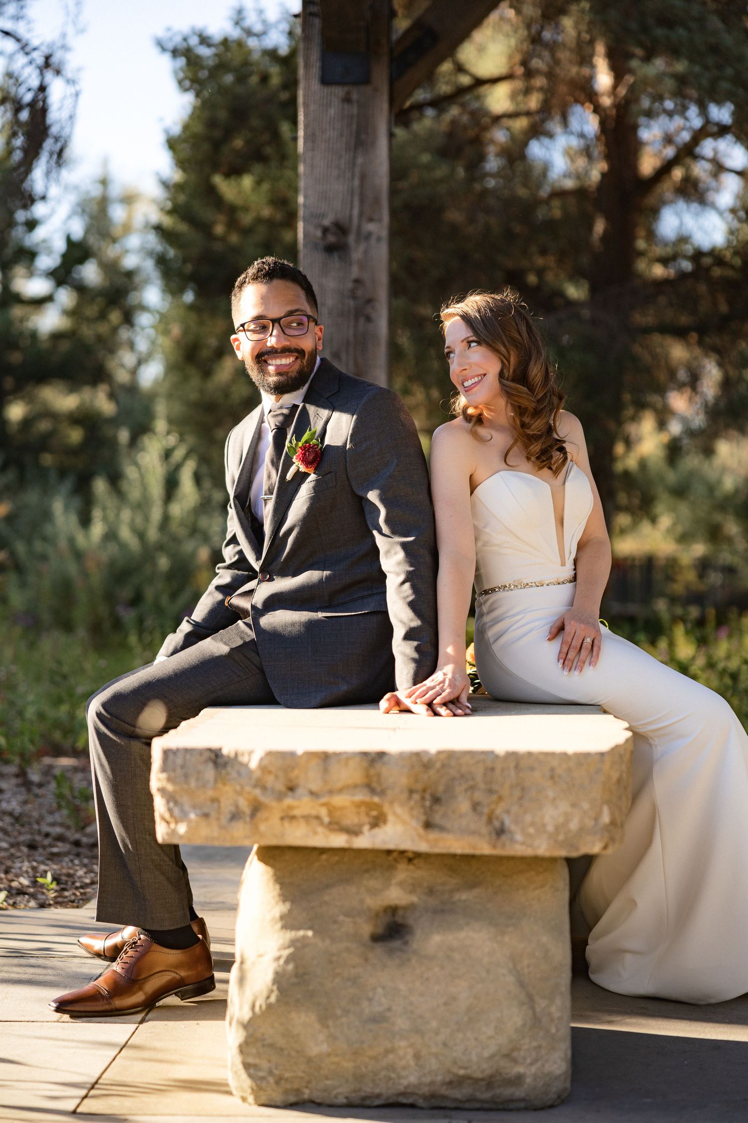 A joyful dancing moment between newlyweds under a wooden pavilion with garden backdrop.