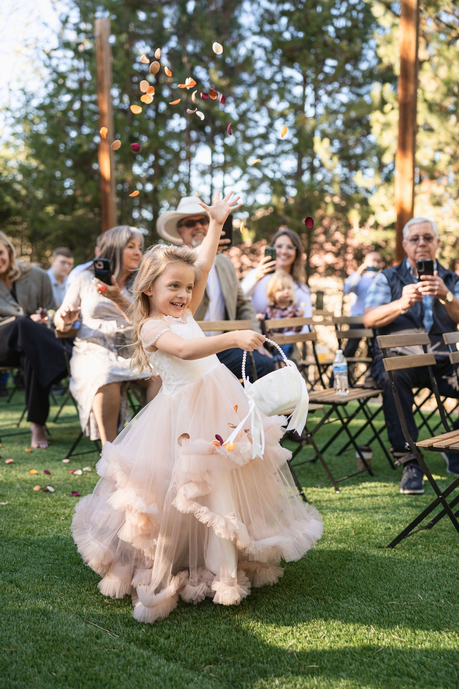 Joyful celebration with dancing on grass during outdoor wedding reception.