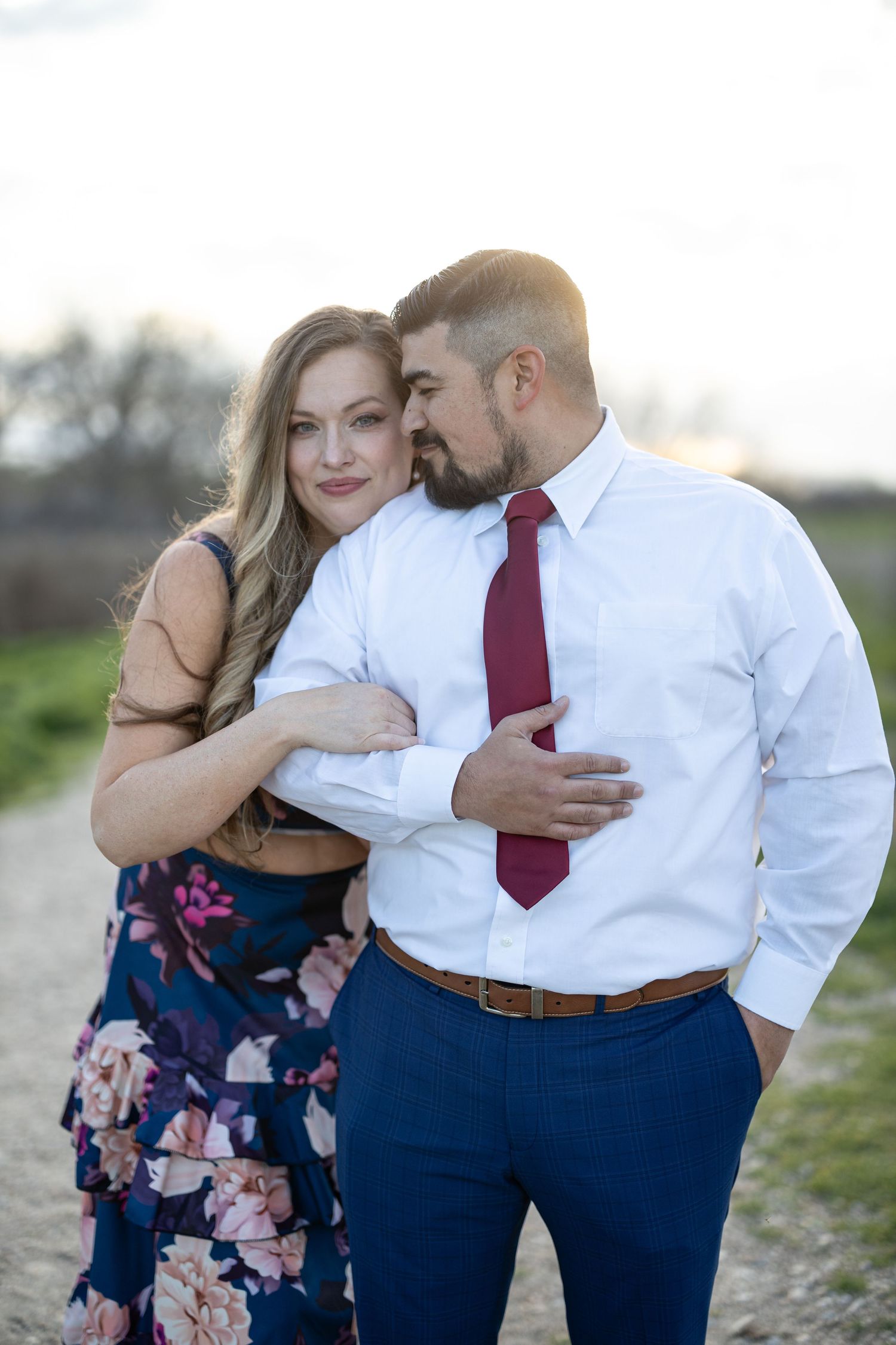 Tender embrace captured during a countryside photoshoot at dusk.