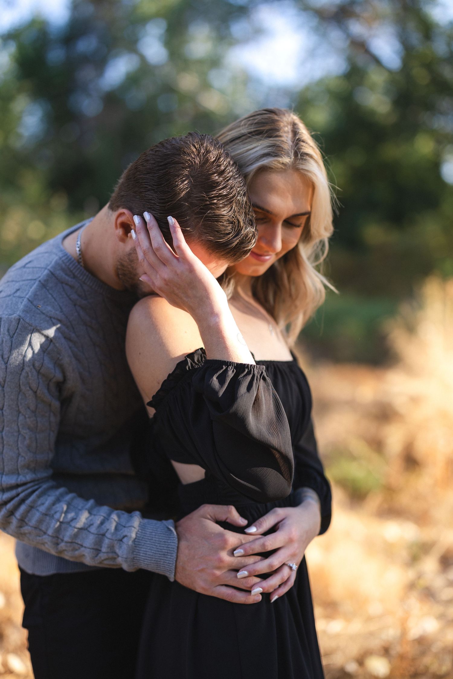 Intimate moment between couple in outdoor setting during golden hour.