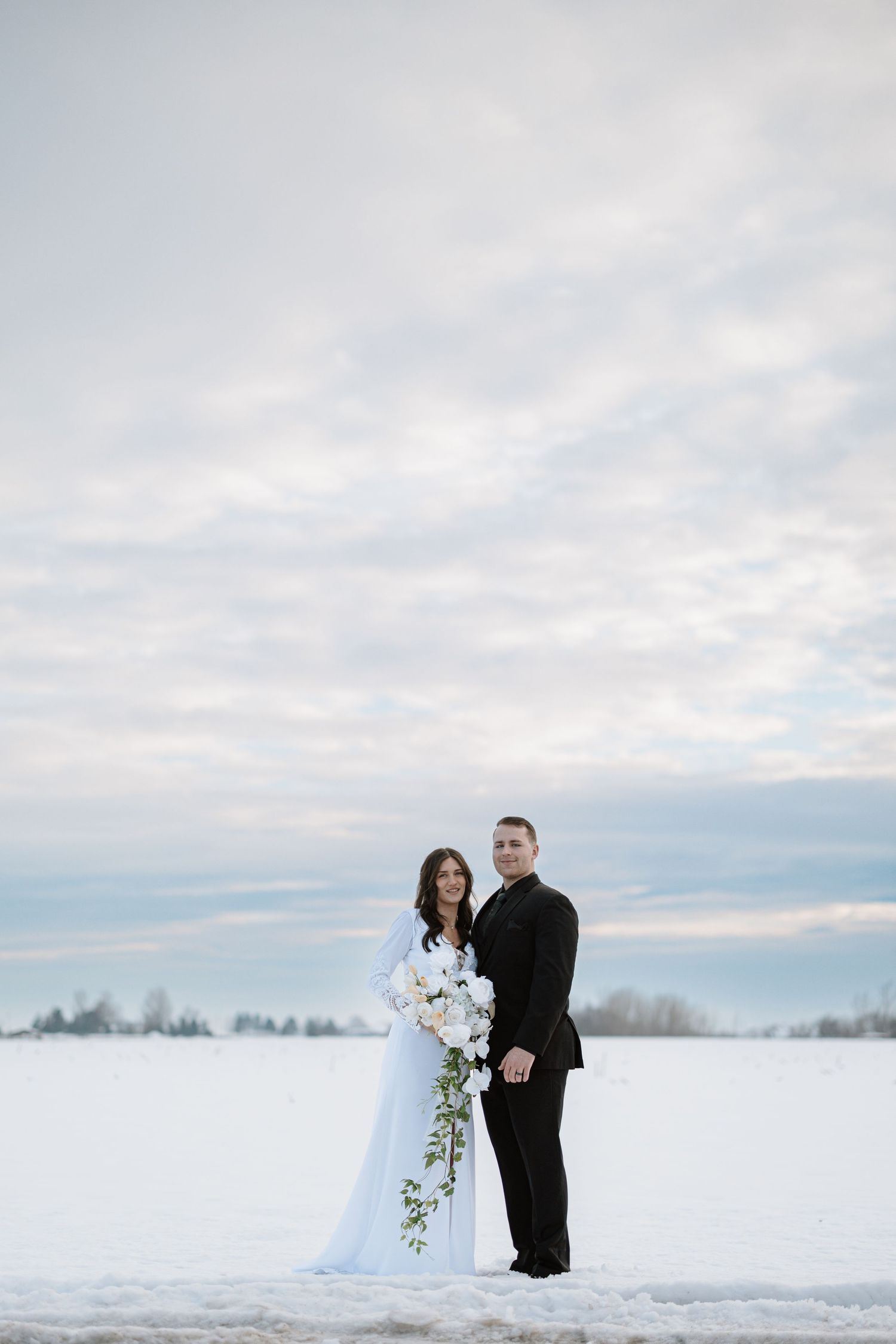 Romantic close-up of couple in formal winter wedding attire.
