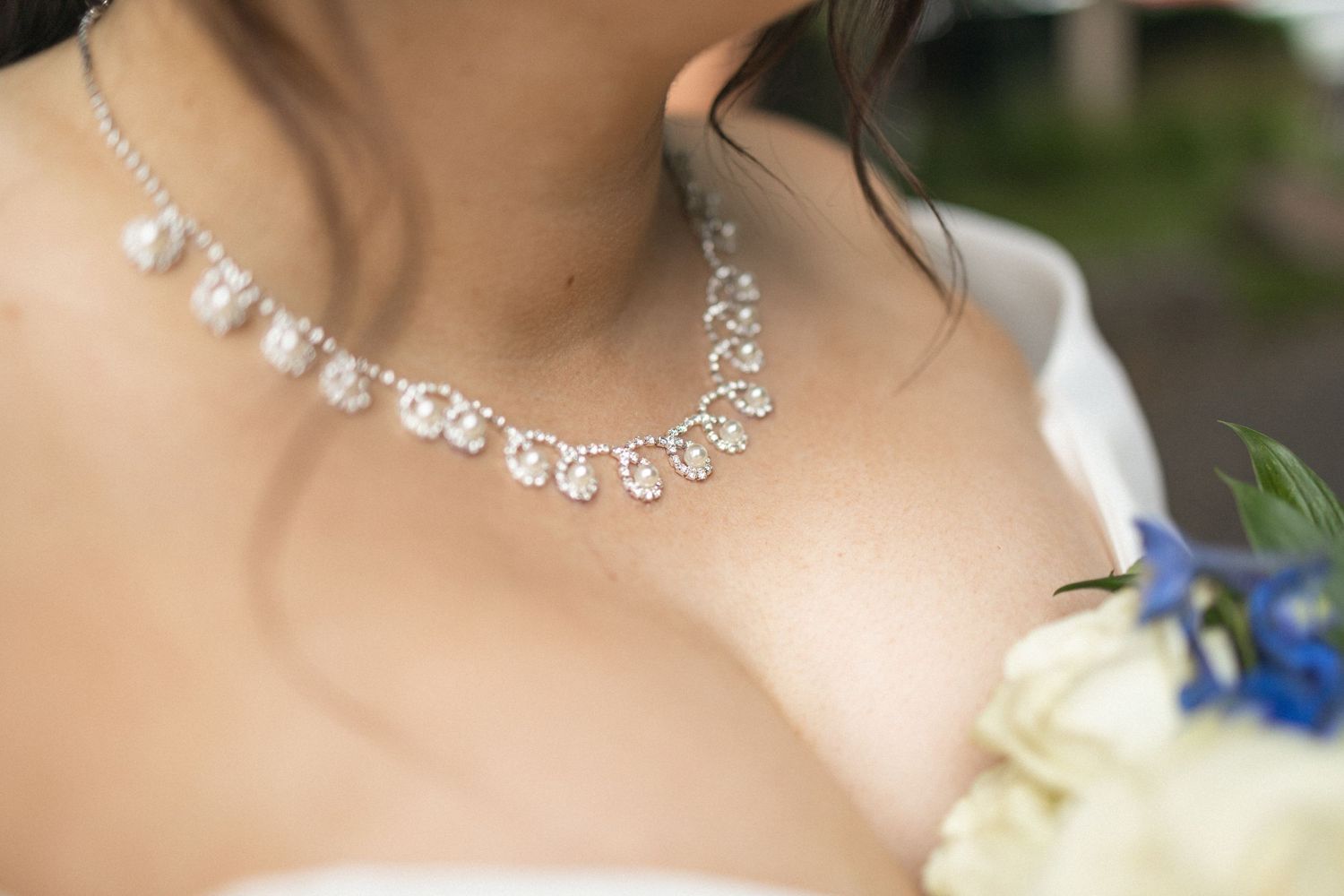 Close-up of a delicate crystal necklace worn with a bridal gown.