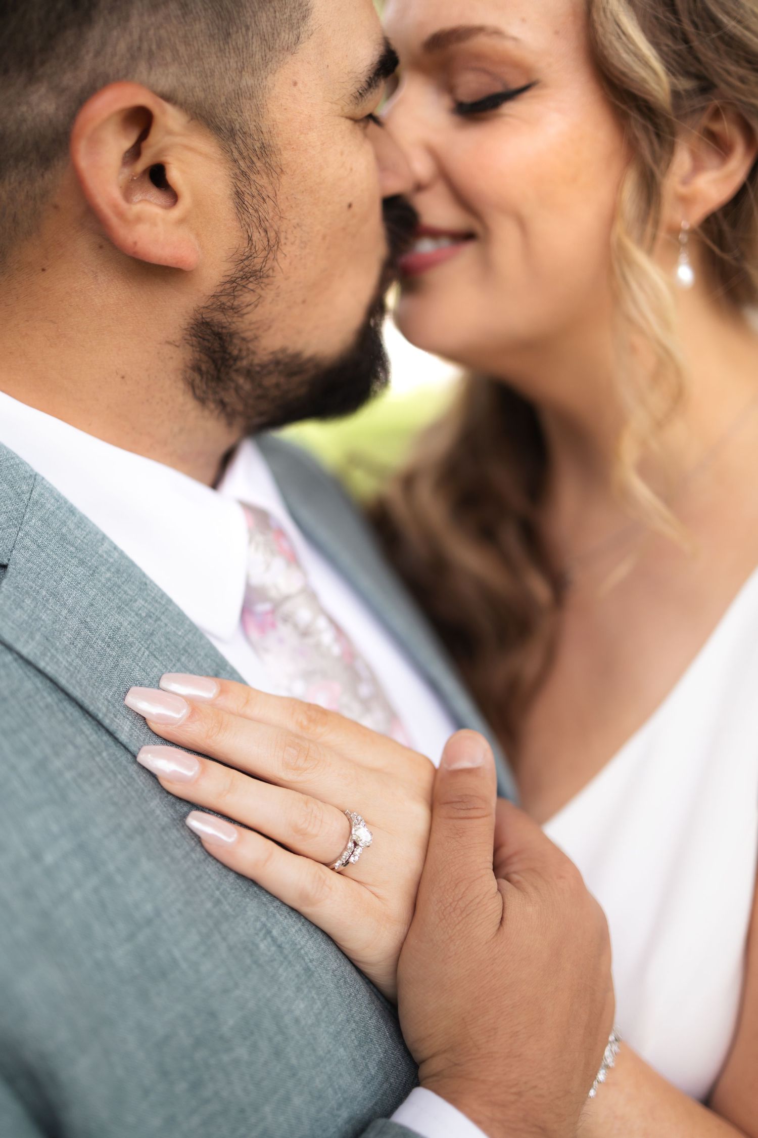 Intimate close-up moment between newlyweds showing wedding ring detail.