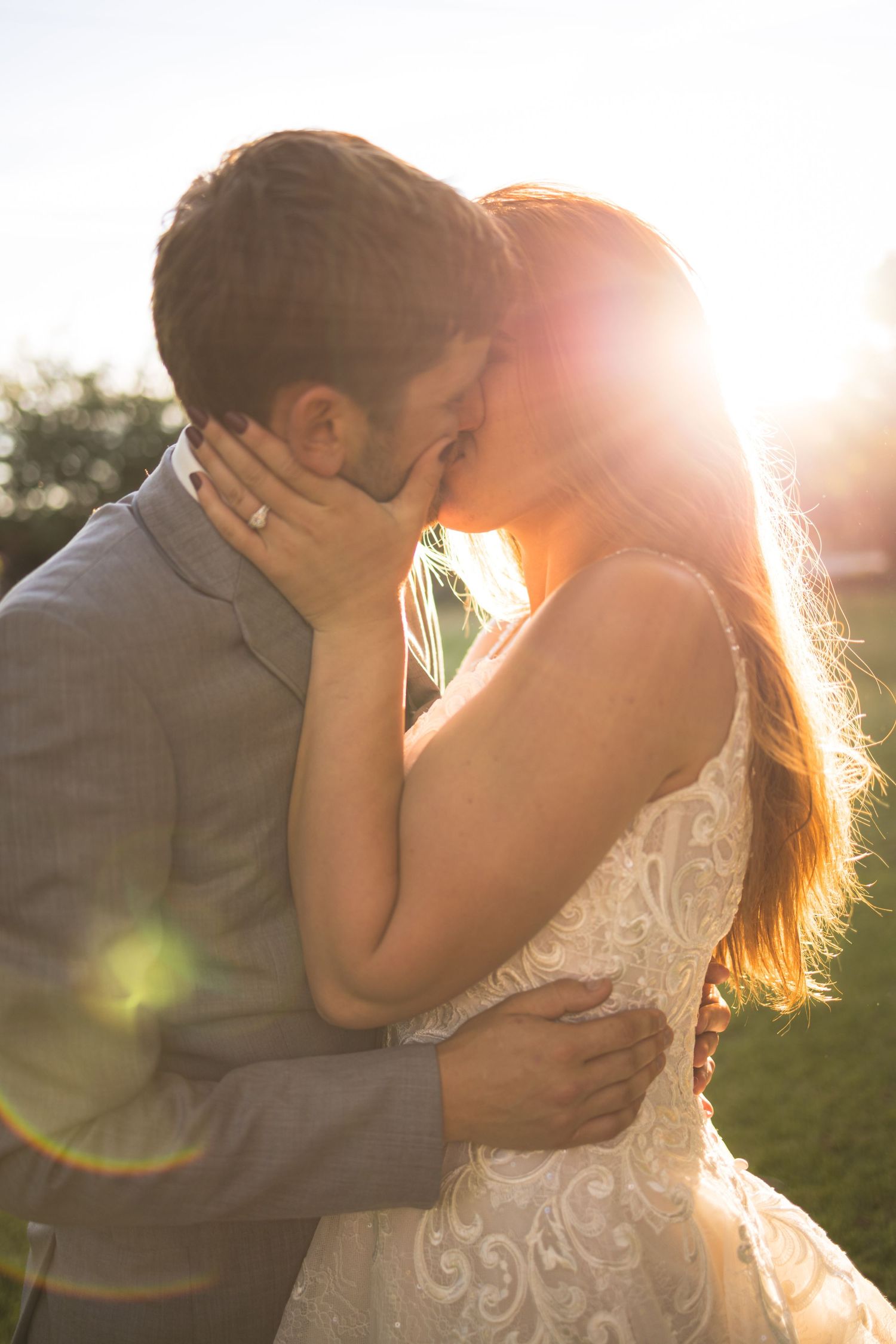 An intimate wedding moment captured in golden sunlight on a summer evening.