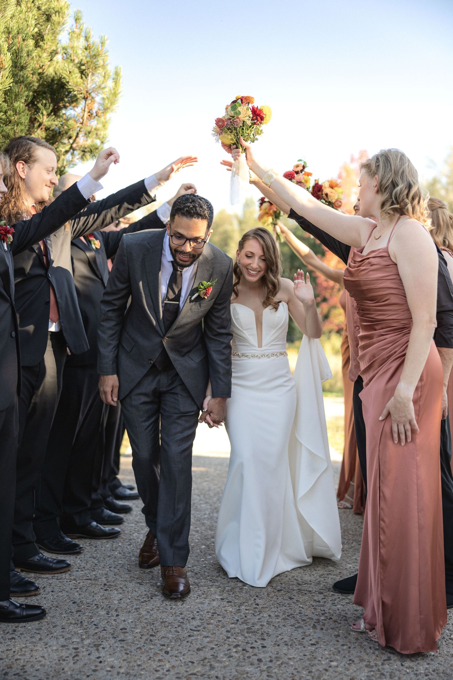 Wedding celebration with guests forming a tunnel as couple walks through.