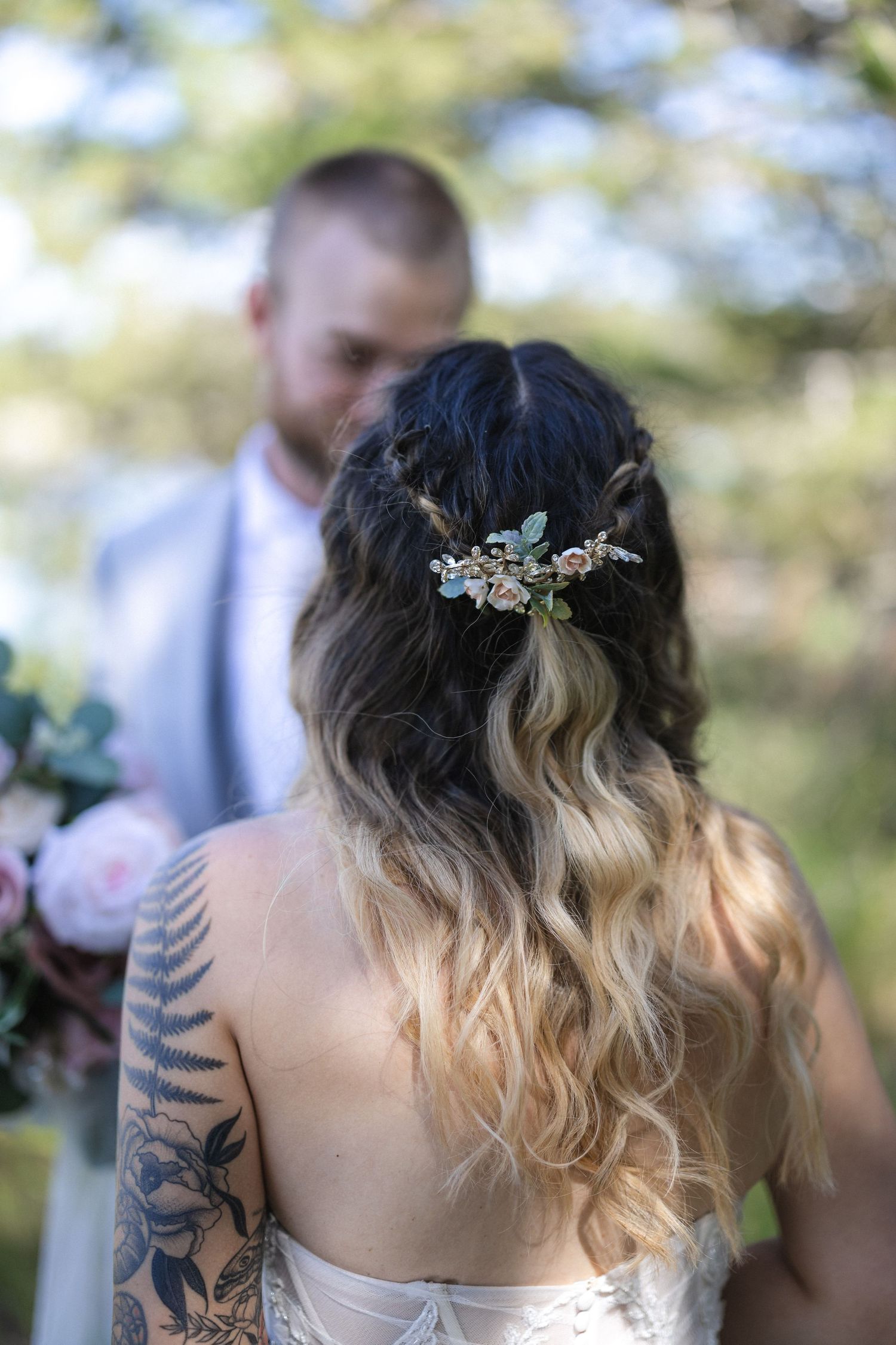 Delicate floral hair accessories adorn a bride's flowing blonde ombre hairstyle.