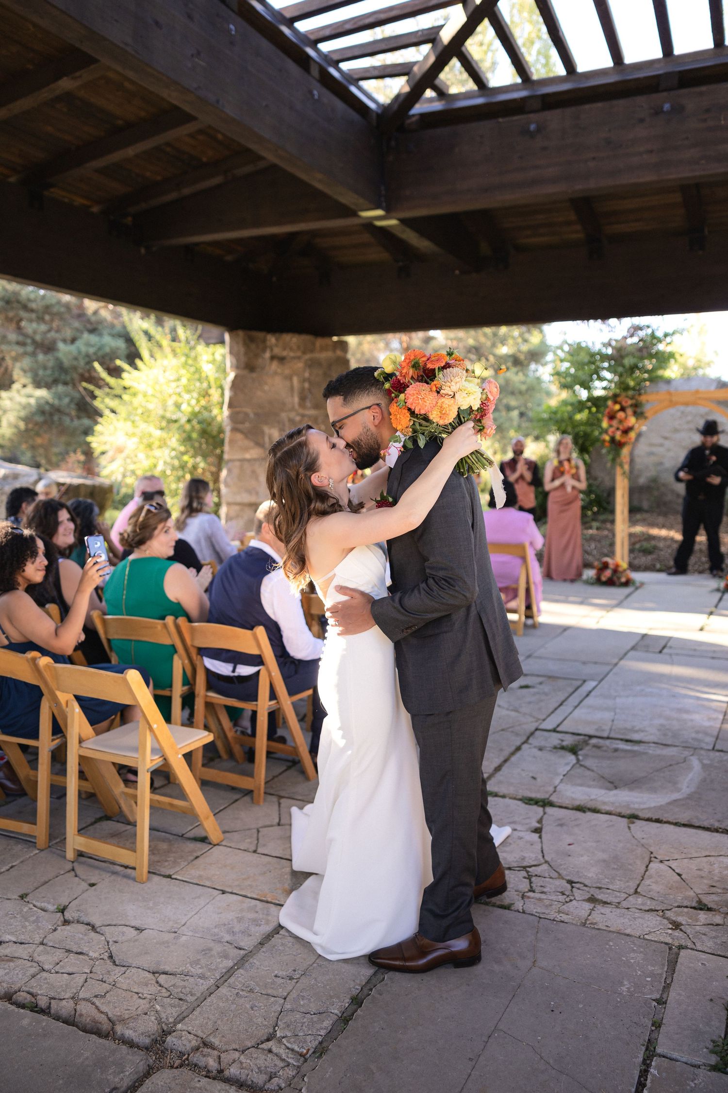 Wedding ceremony moments captured under wooden pergola with natural lighting.