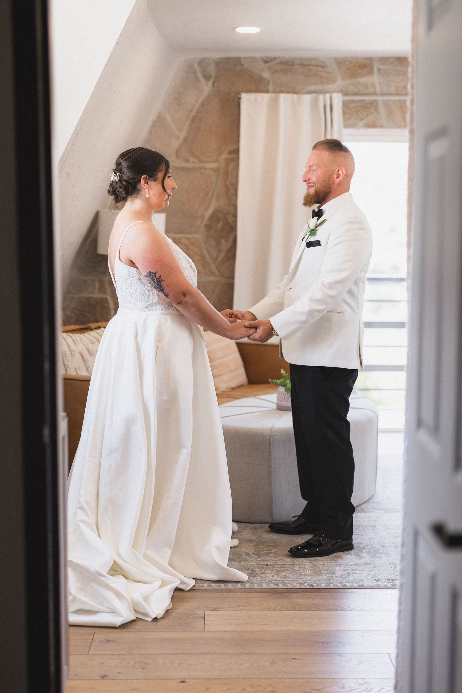 Couple holding hands while standing together in an intimate moment during their wedding day.