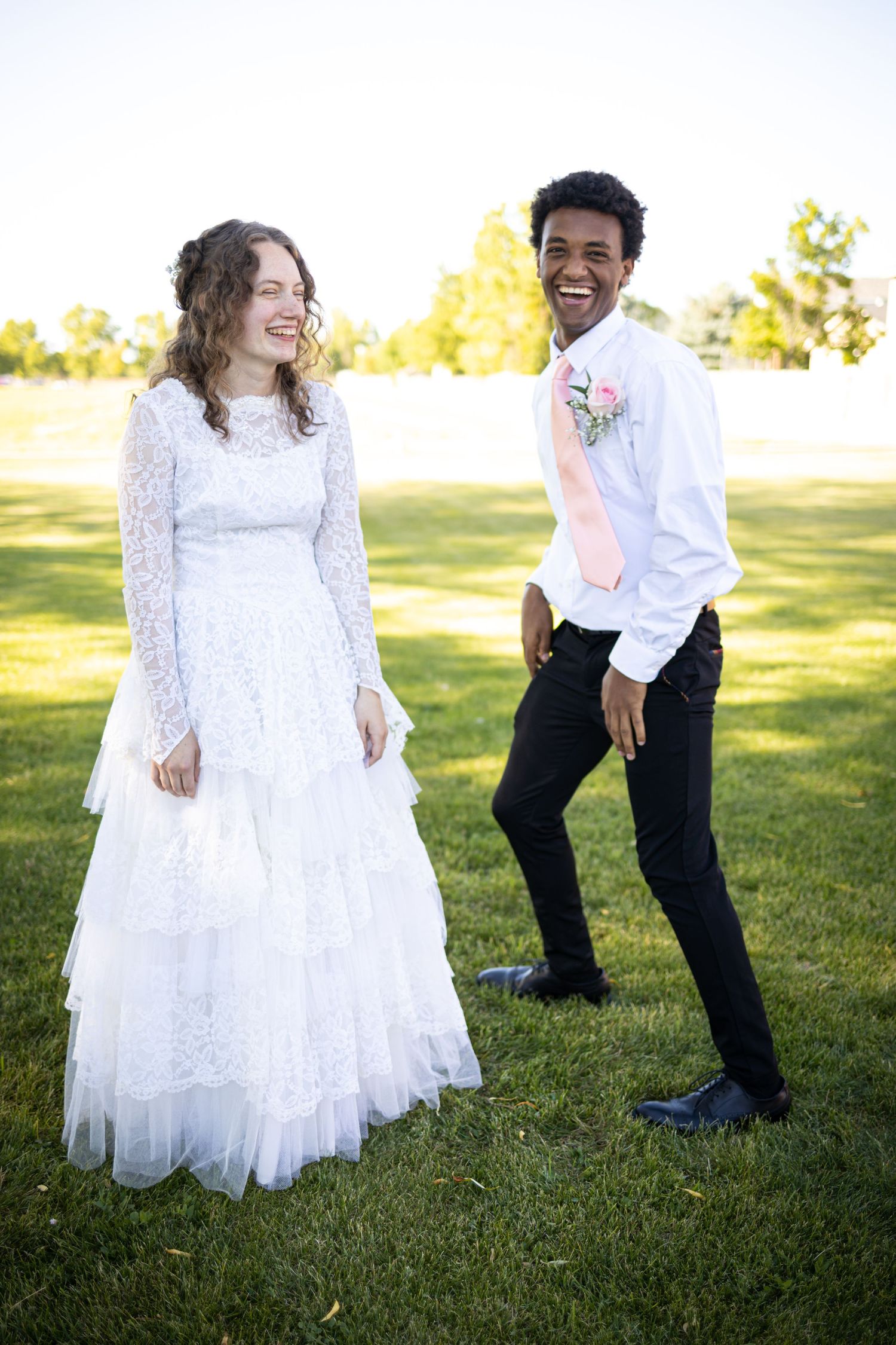 Candid moment of couple laughing together during outdoor wedding photoshoot.