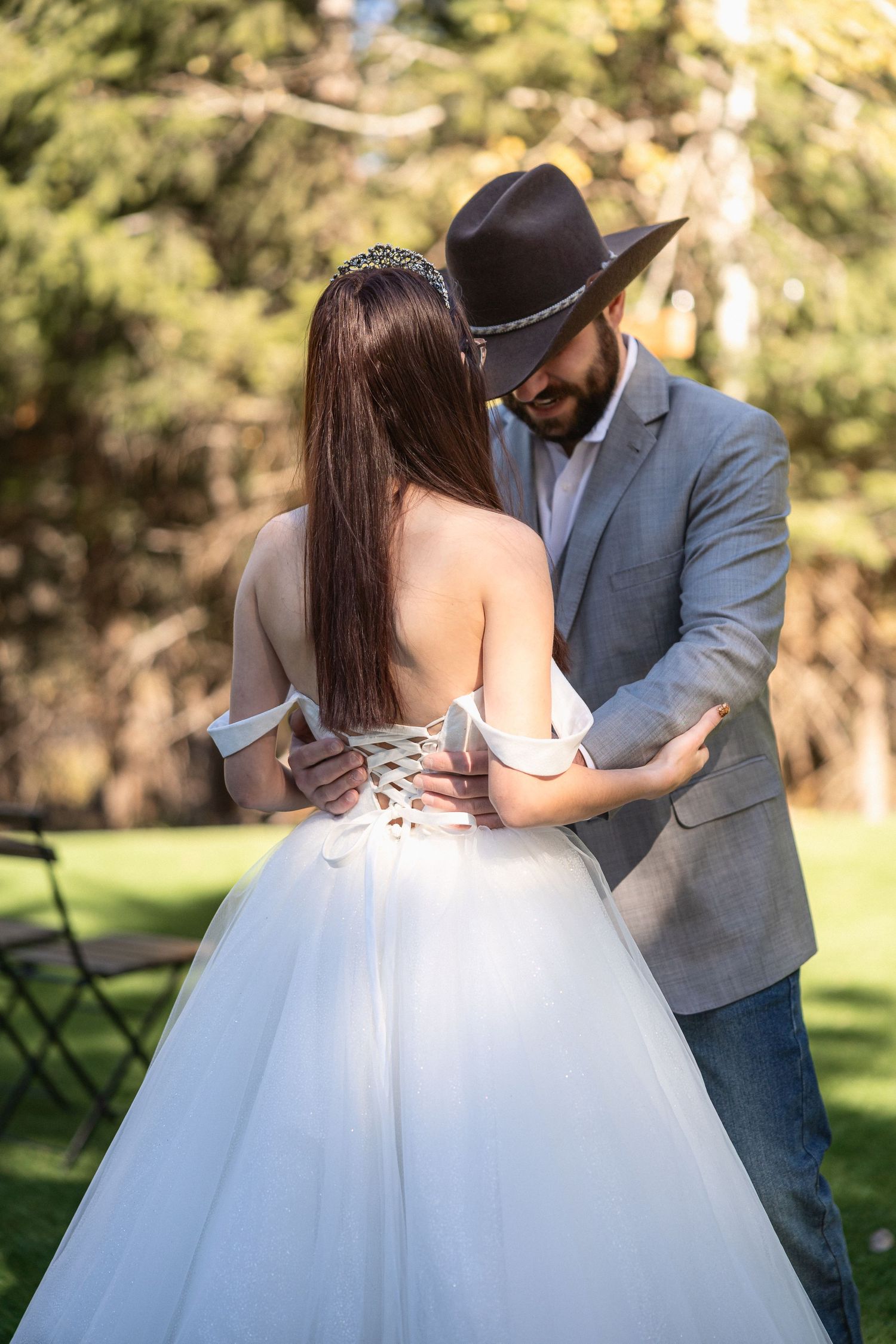 Newlyweds share a romantic dance moment in a sunny outdoor garden setting.