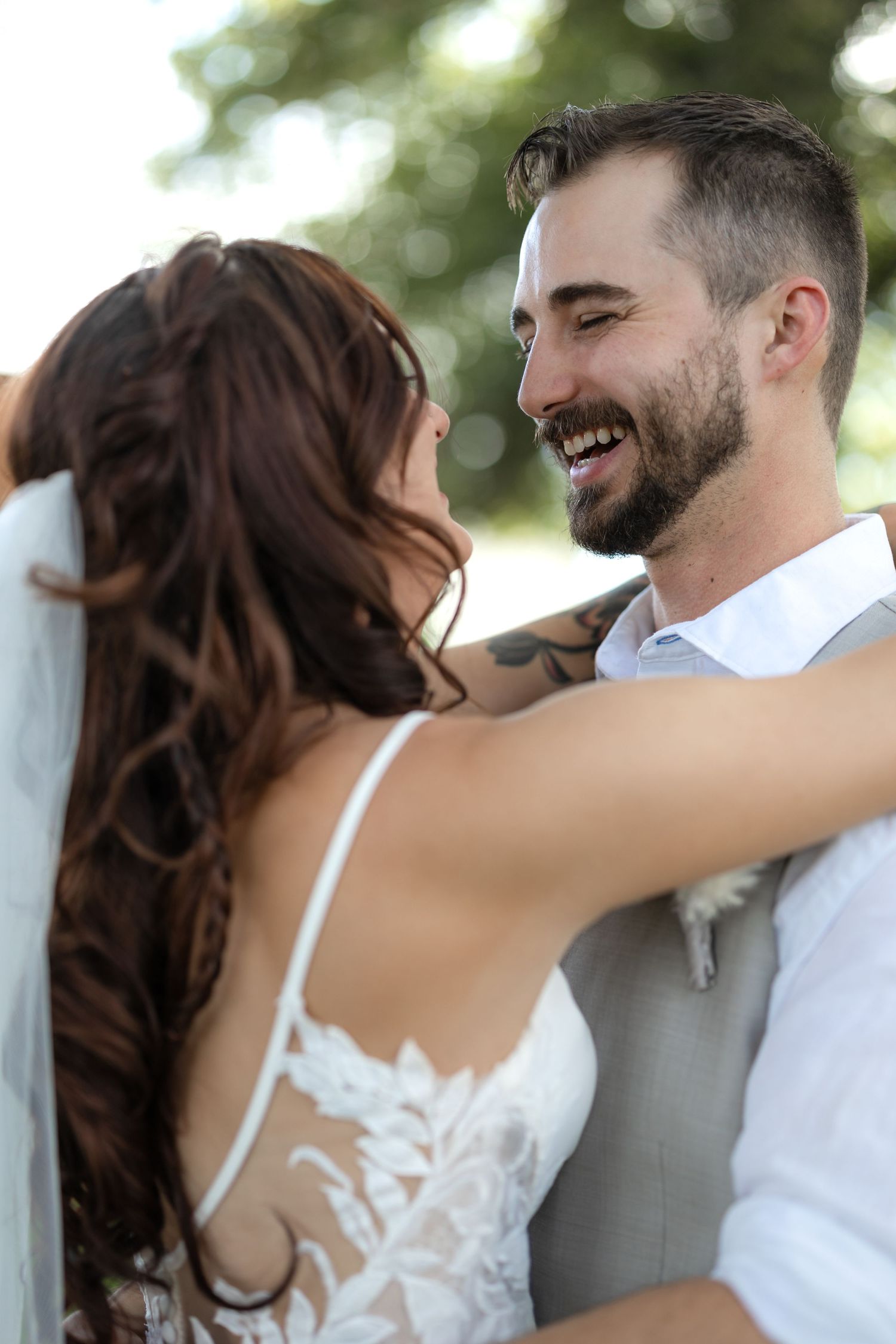 Intimate moment between newlyweds sharing laughter during their wedding photoshoot.
