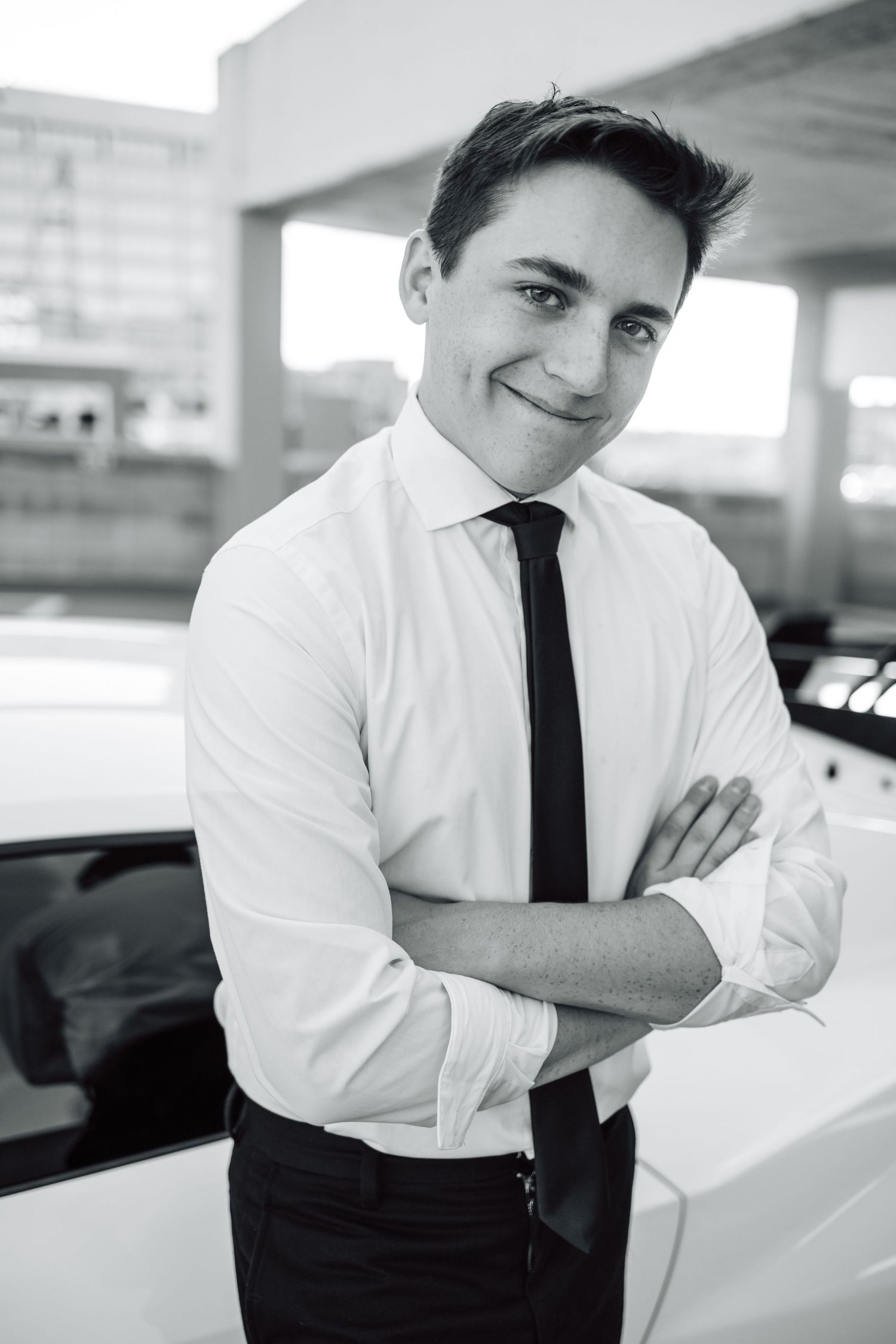 Black and white portrait of someone in formal attire in parking garage setting.
