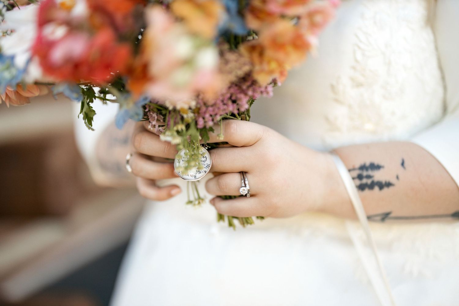 Wedding bouquet with colorful flowers and rings captured in natural light.