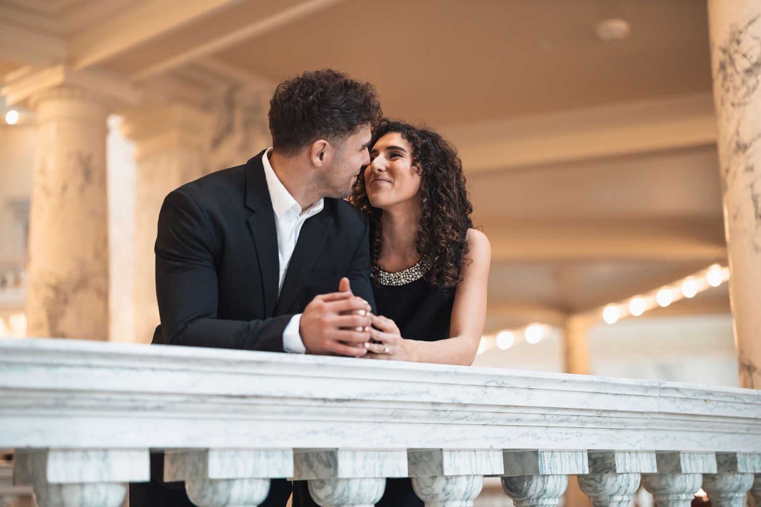 An intimate moment shared between a couple at an ornate indoor venue with magical lighting.