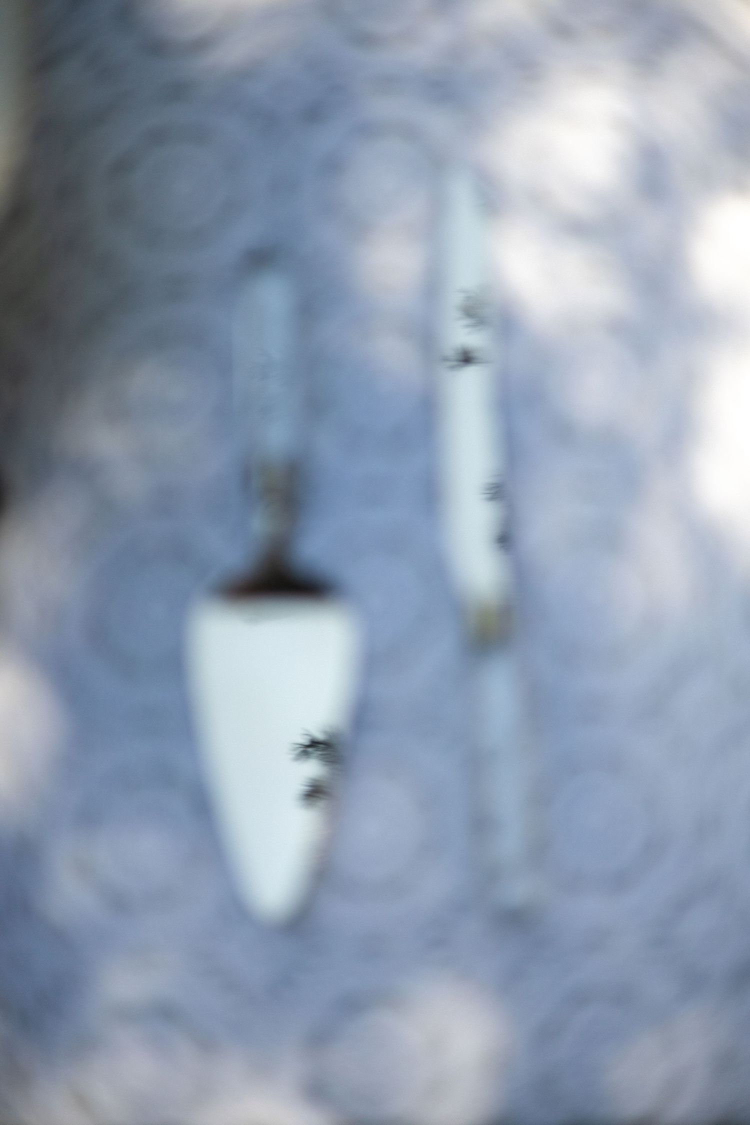 Abstract blurred image of white decorative elements against blue background.