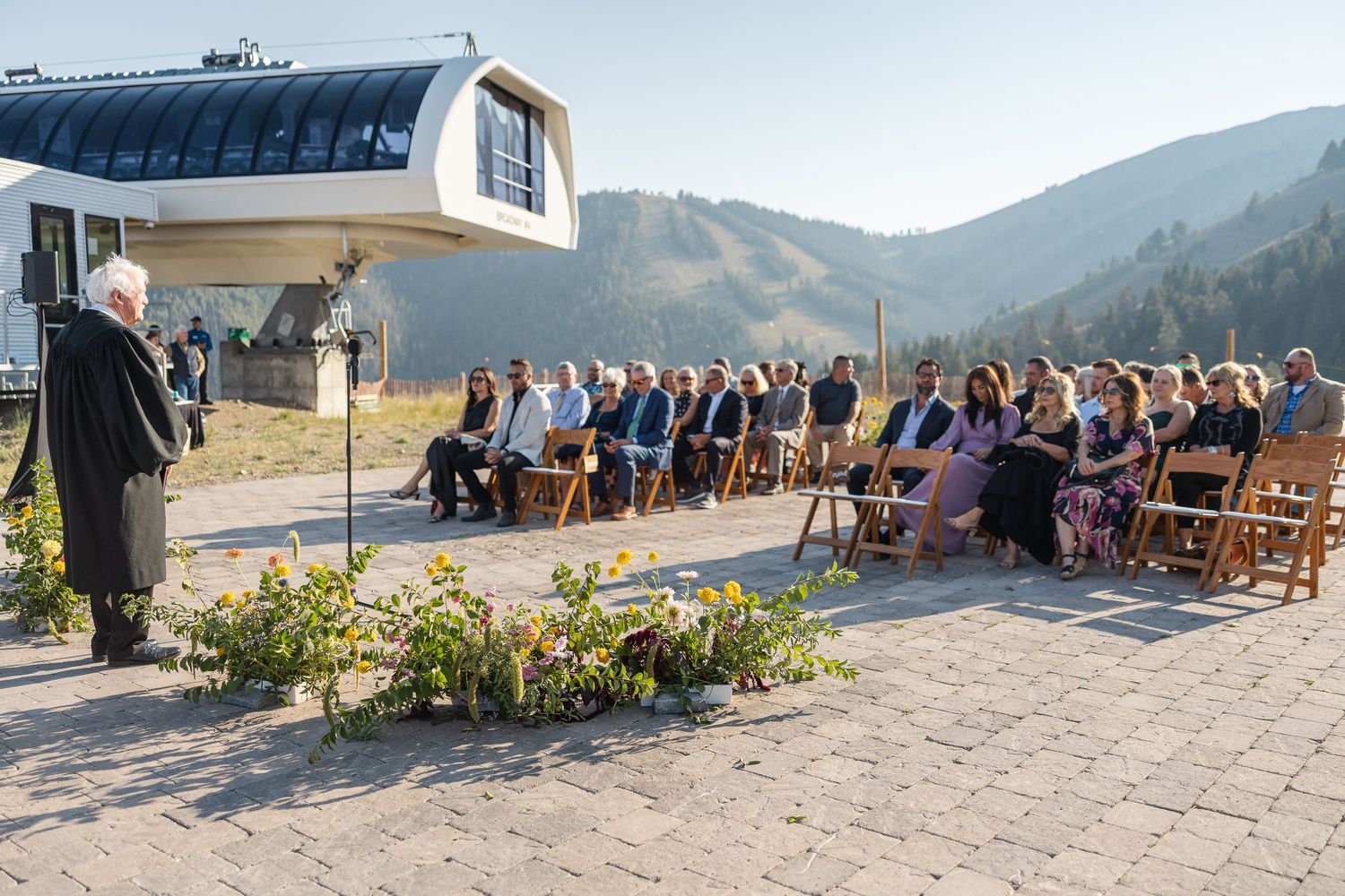 Outdoor wedding venue with rows of wooden chairs facing mountain vista.