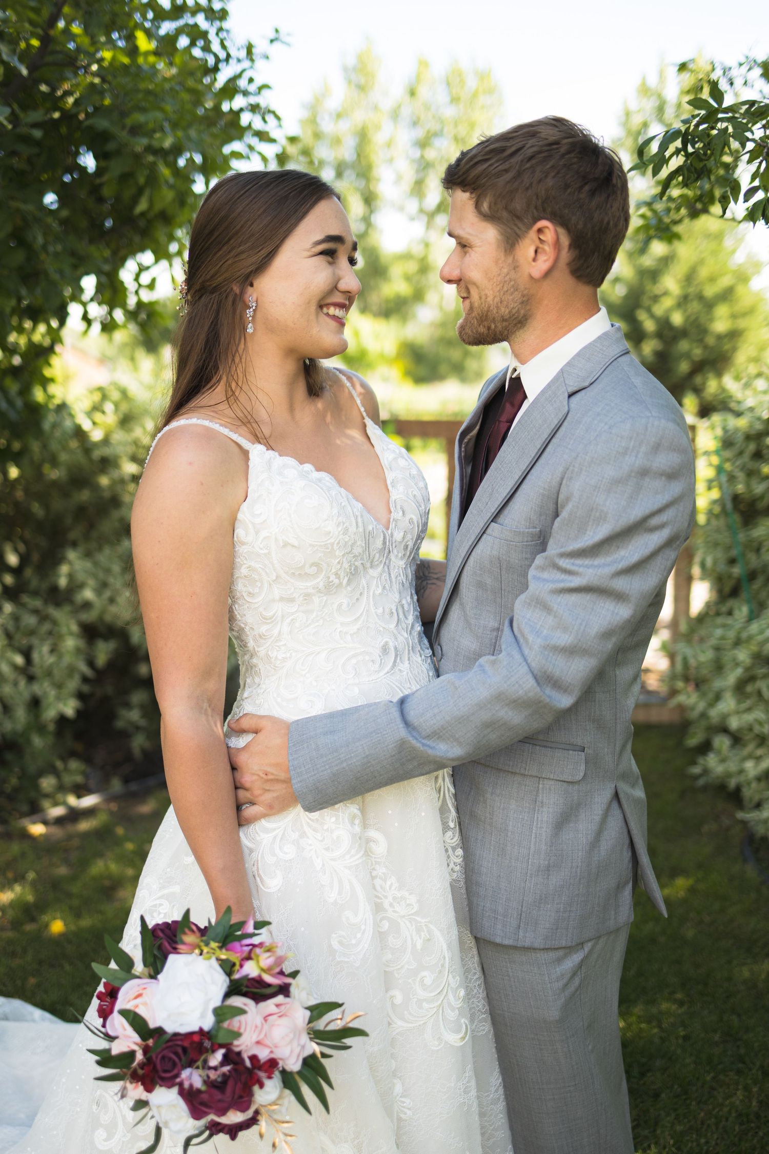 A joyful moment captured between newlyweds in an outdoor garden setting.