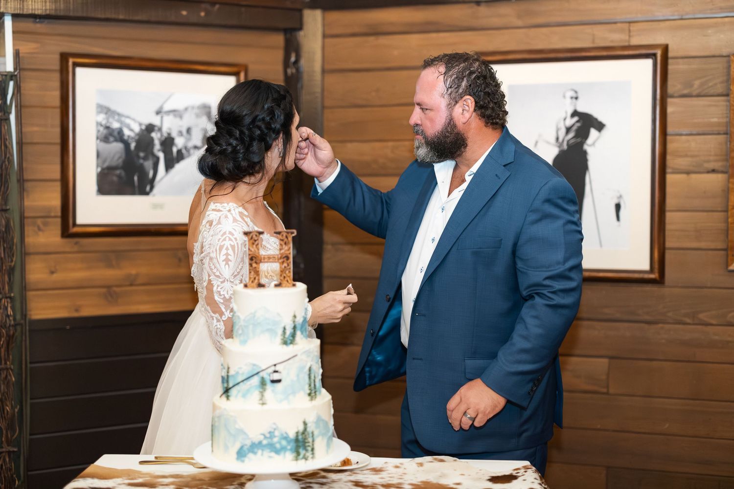 A couple enjoys a lighthearted moment while sharing their wedding cake.