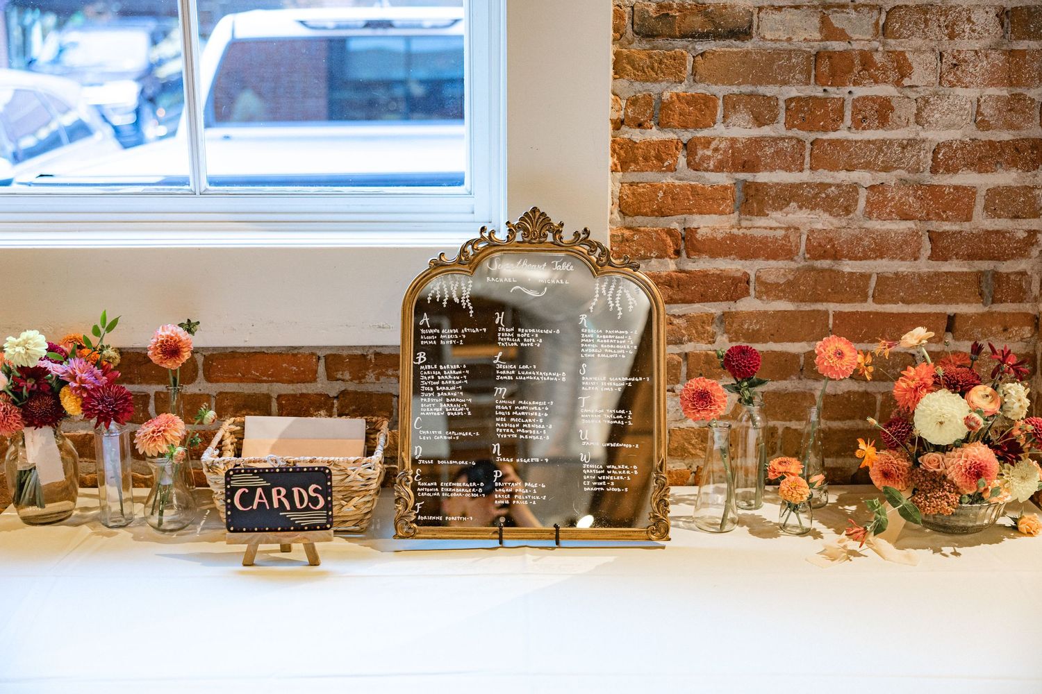 Rustic wedding decor featuring floral arrangements and wooden accents on exposed brick wall.