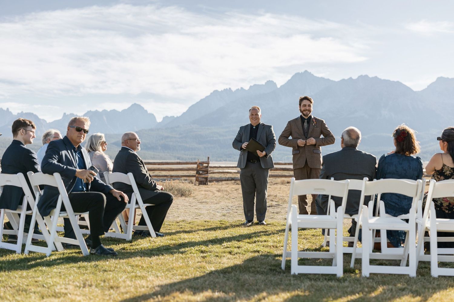 White chairs arranged for an outdoor wedding ceremony with mountain views.