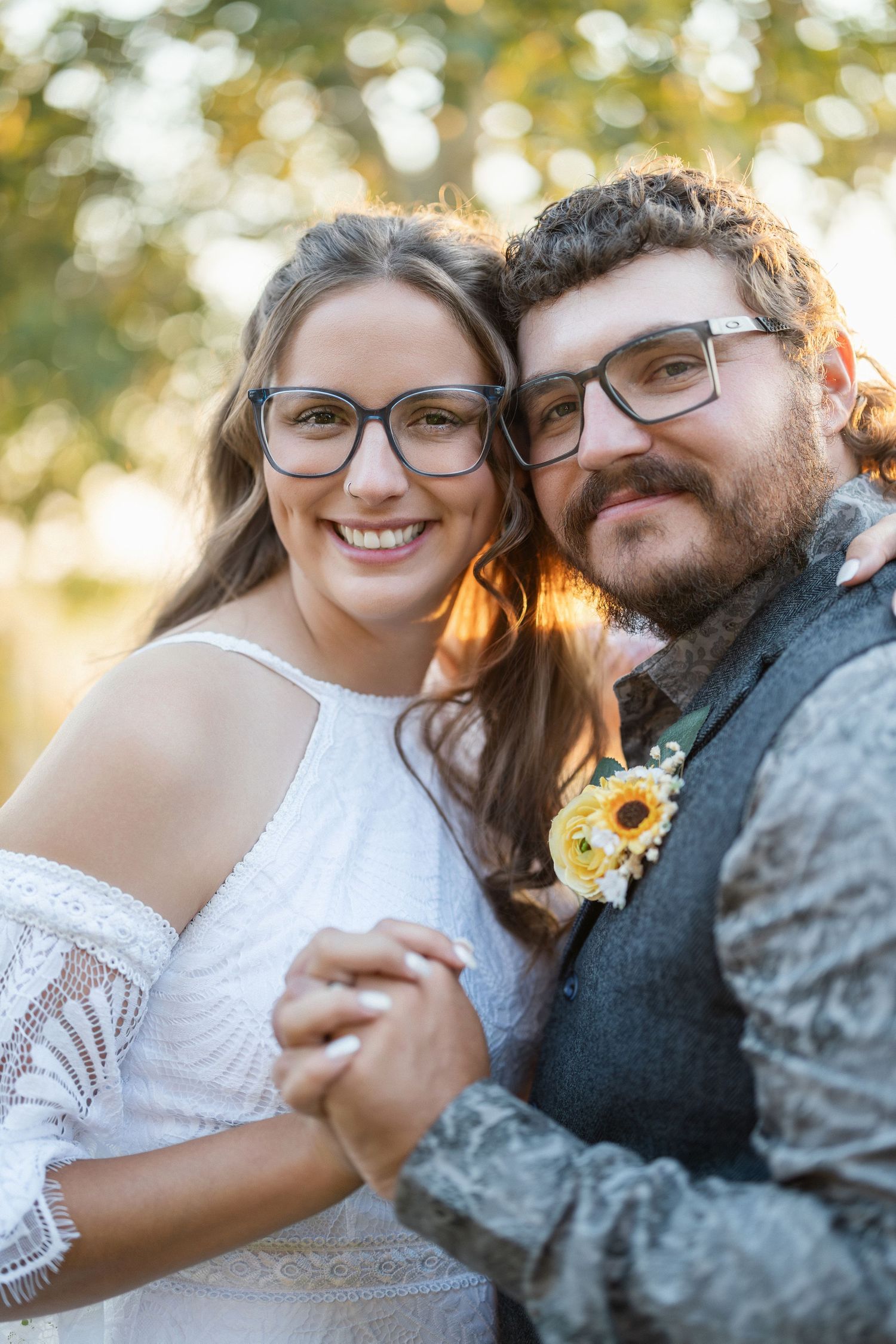 A couple shares intimate moments outdoors with sunflowers during a romantic photoshoot at golden hour.