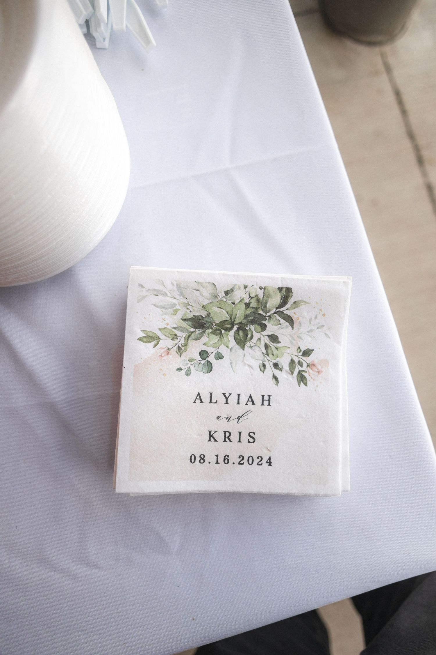 Wedding invitation detail showing floral design and couple's names Alyiah and Kris with August 2024 wedding date.