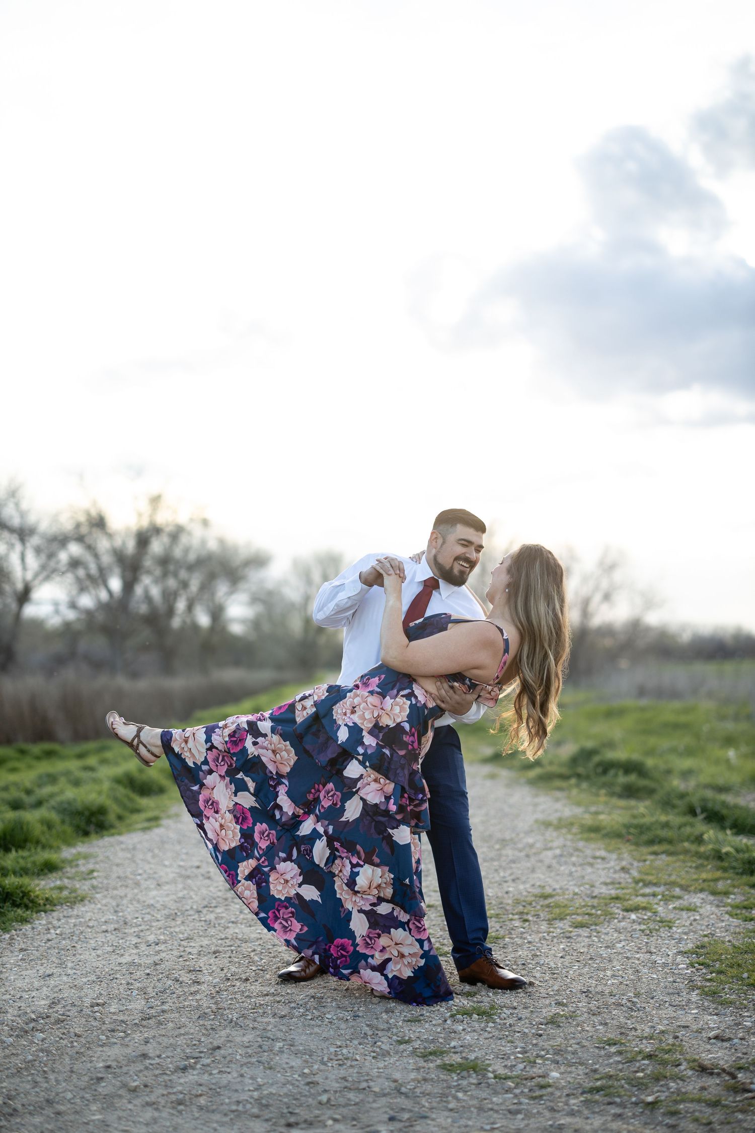 Playful dancing moment captured on a countryside path at sunset.