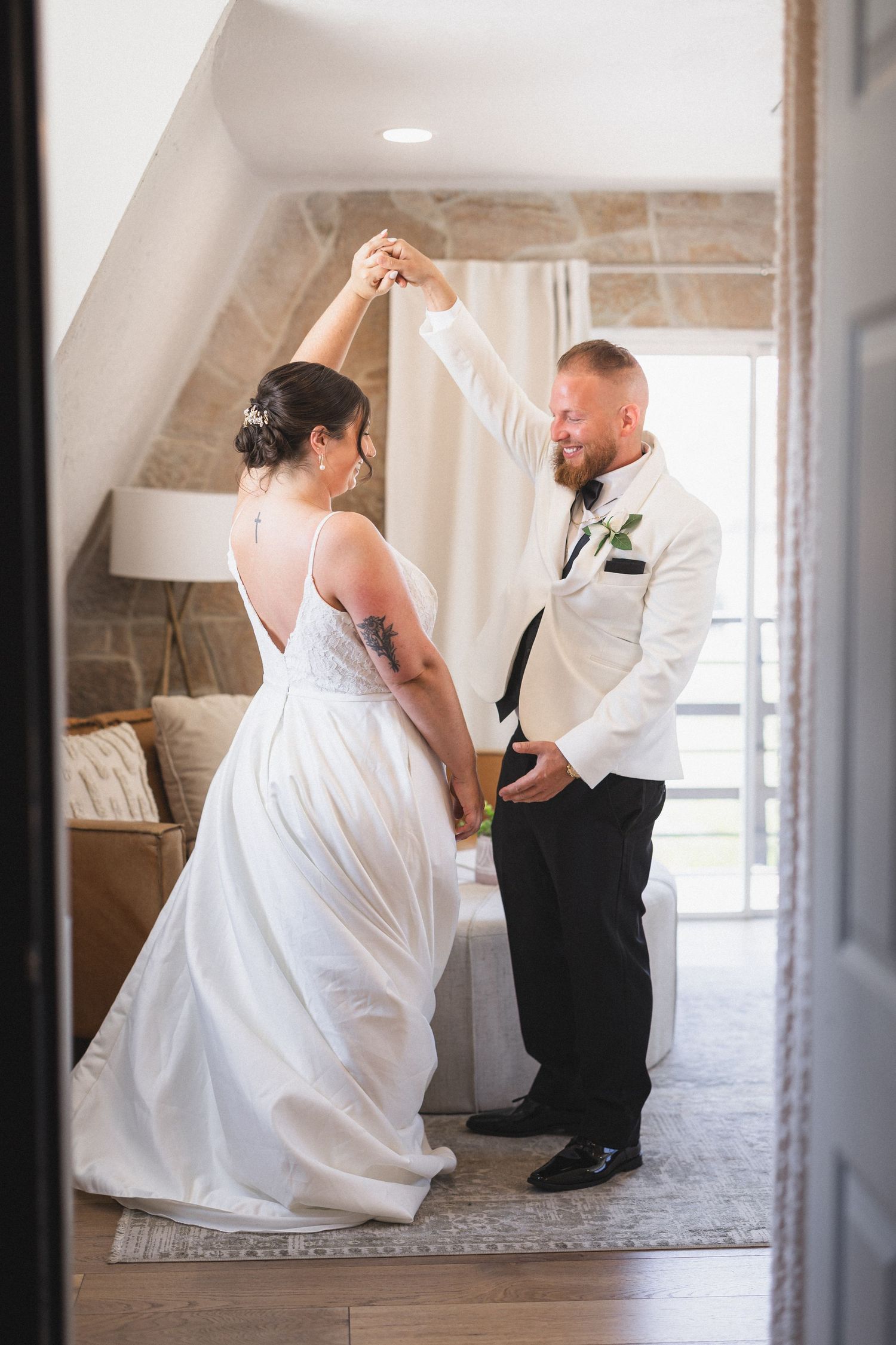 Dancing couple share an intimate moment in an elegant indoor setting with stone wall details.