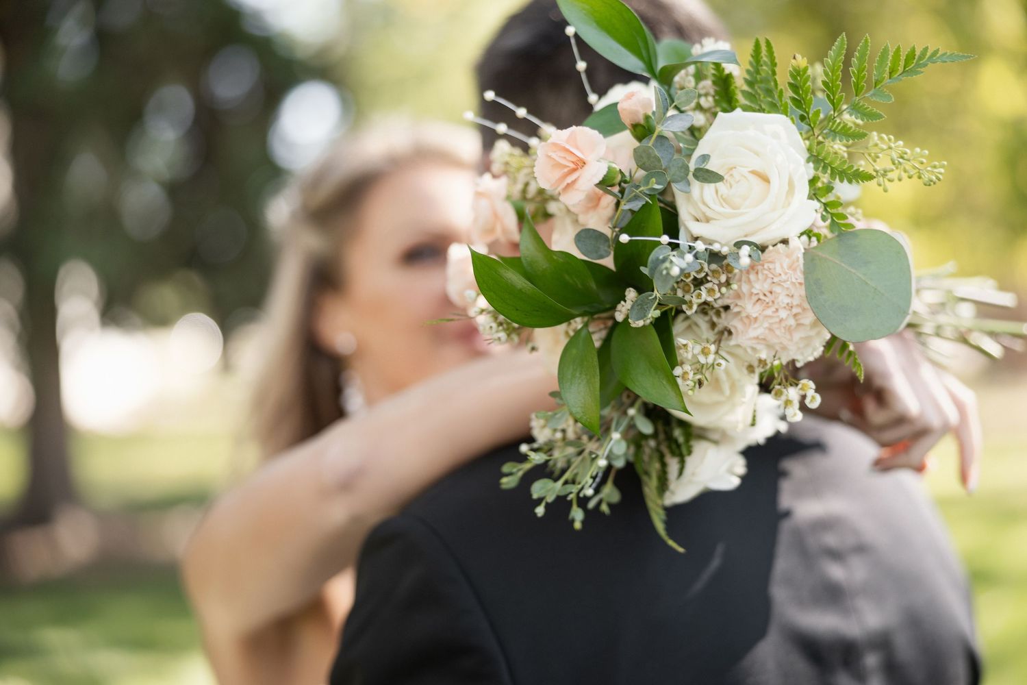 Elegant white and green floral arrangements with roses and greenery for a wedding.