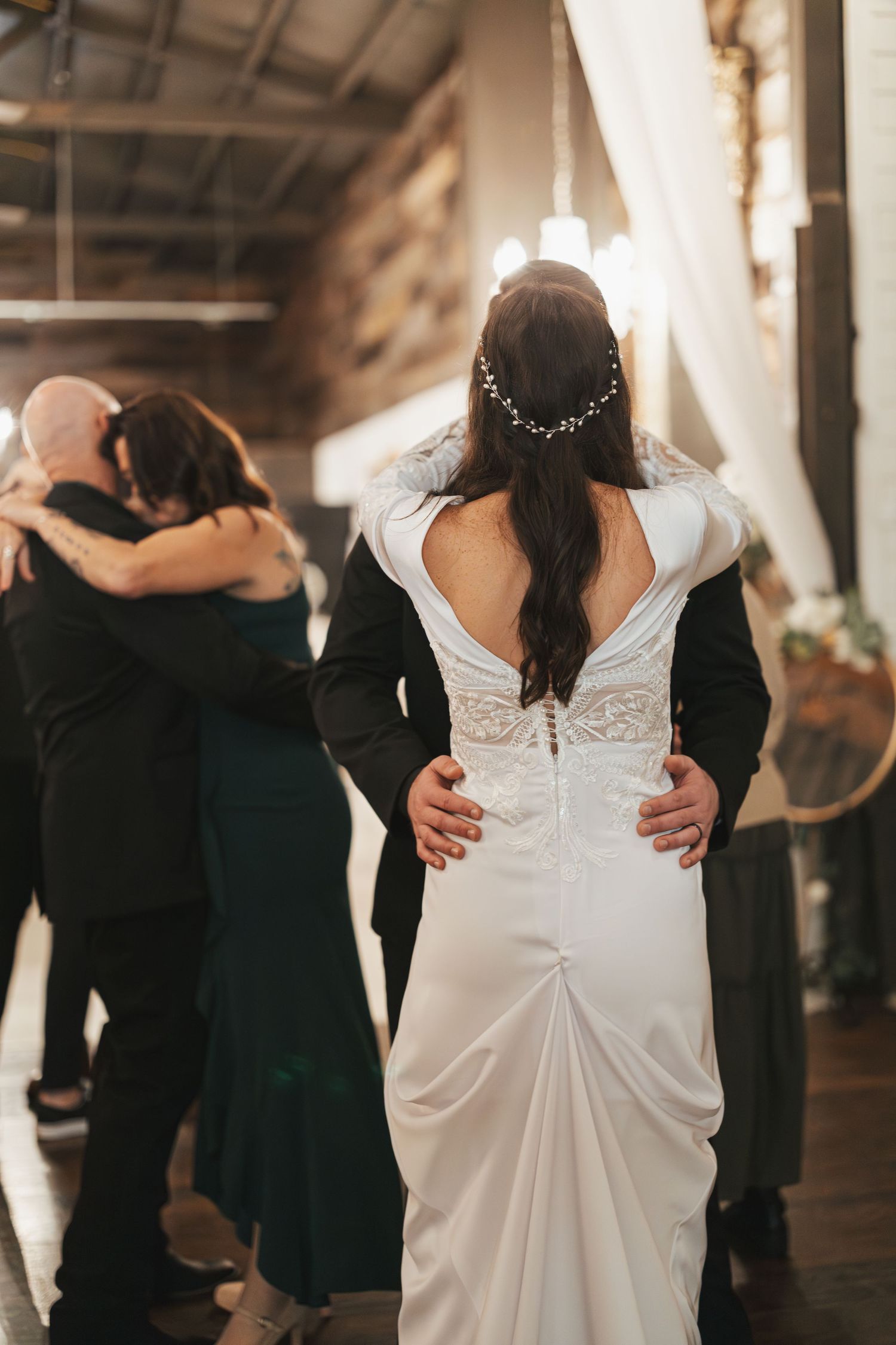 Back view of elegant white wedding dress with delicate lace details during reception.