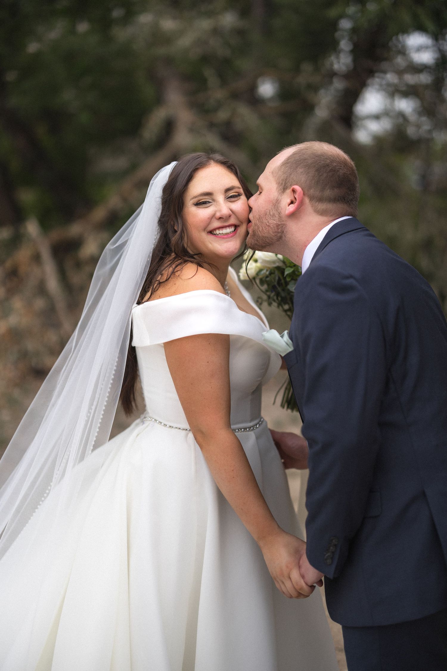 A joyful moment captured as newlyweds share an intimate moment on their wedding day.