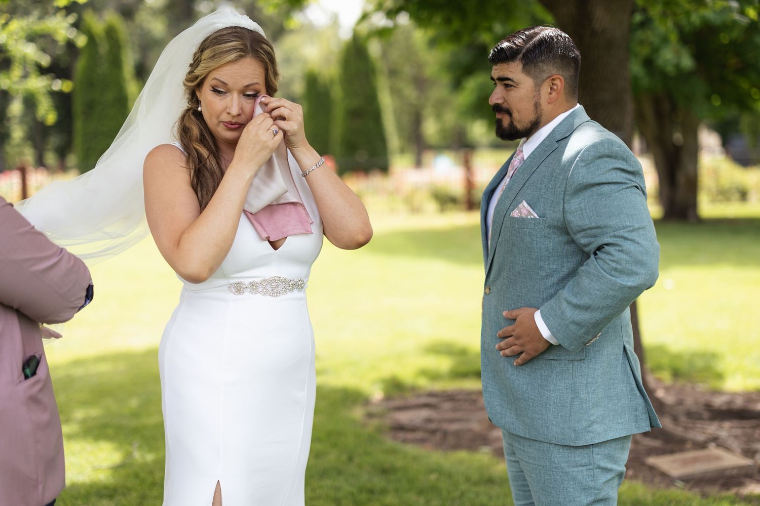 Emotional wedding moment captured in outdoor garden setting.