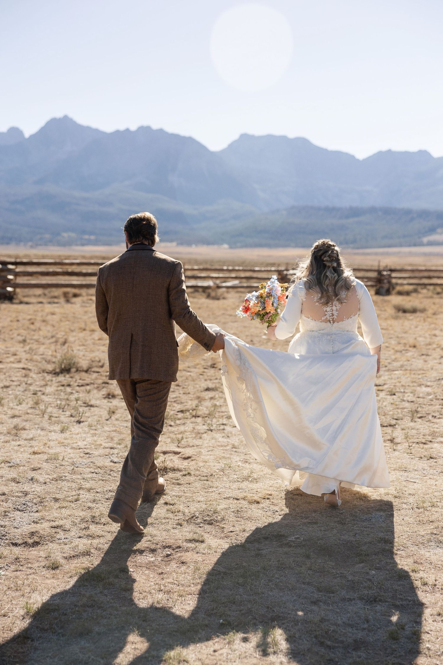 Silhouettes dancing across desert landscape with mountains in background during golden hour.