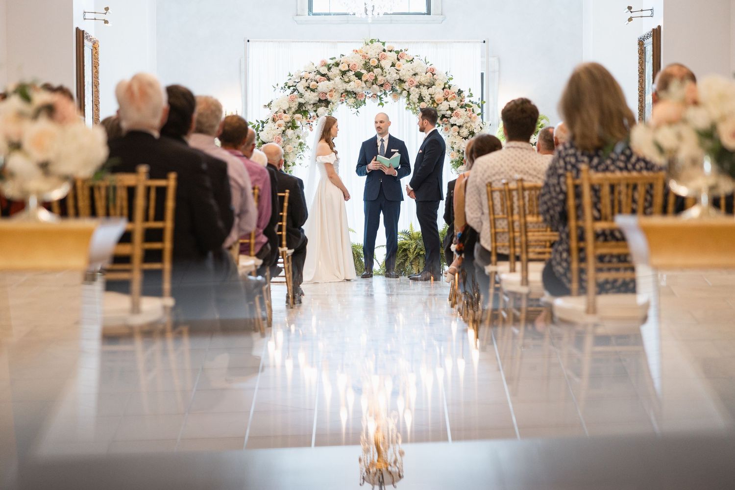 Wedding ceremony view from ground level showing crystal chandelier and floral arrangements.