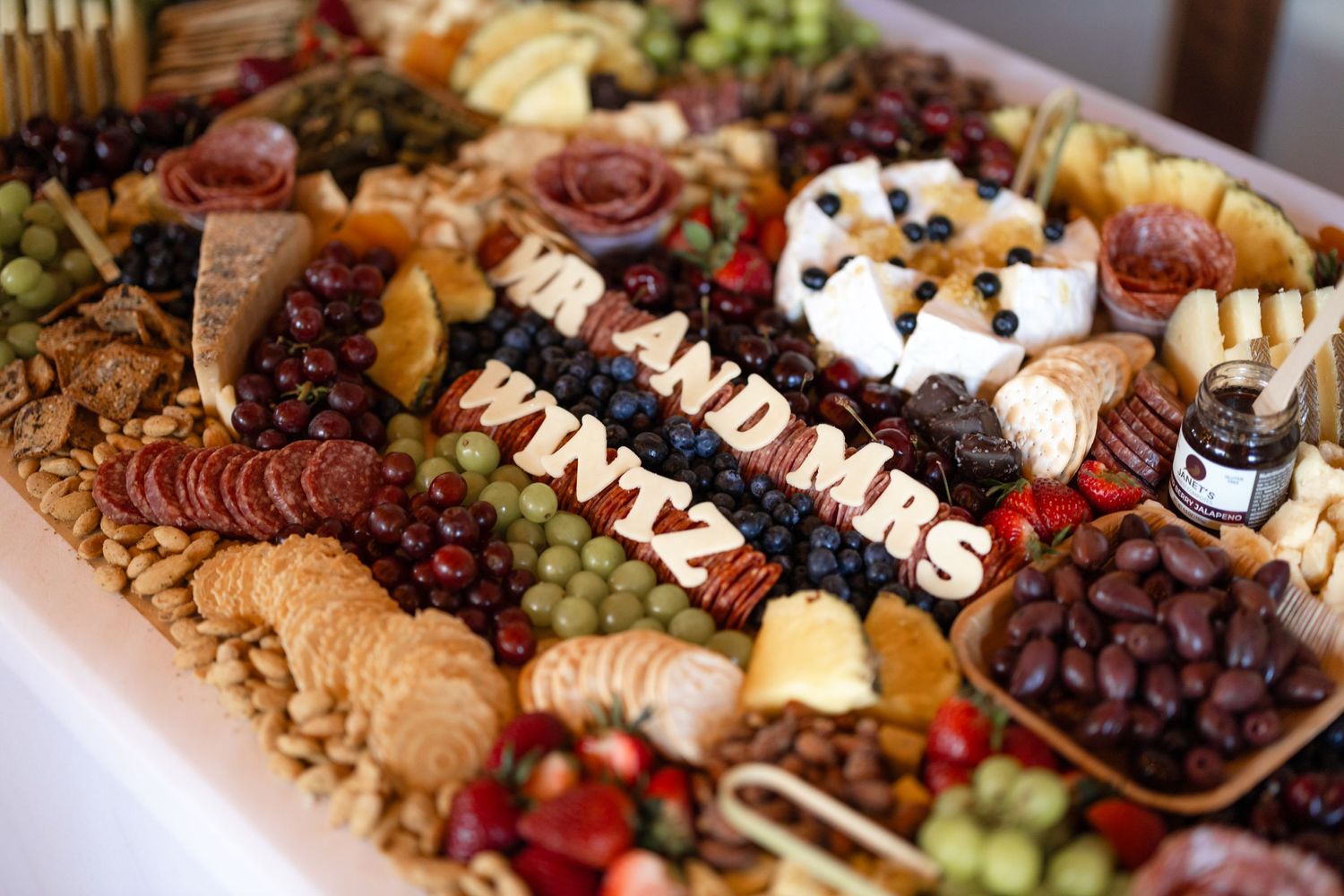 Elegant charcuterie board display with meats, cheeses, fruits and nuts.