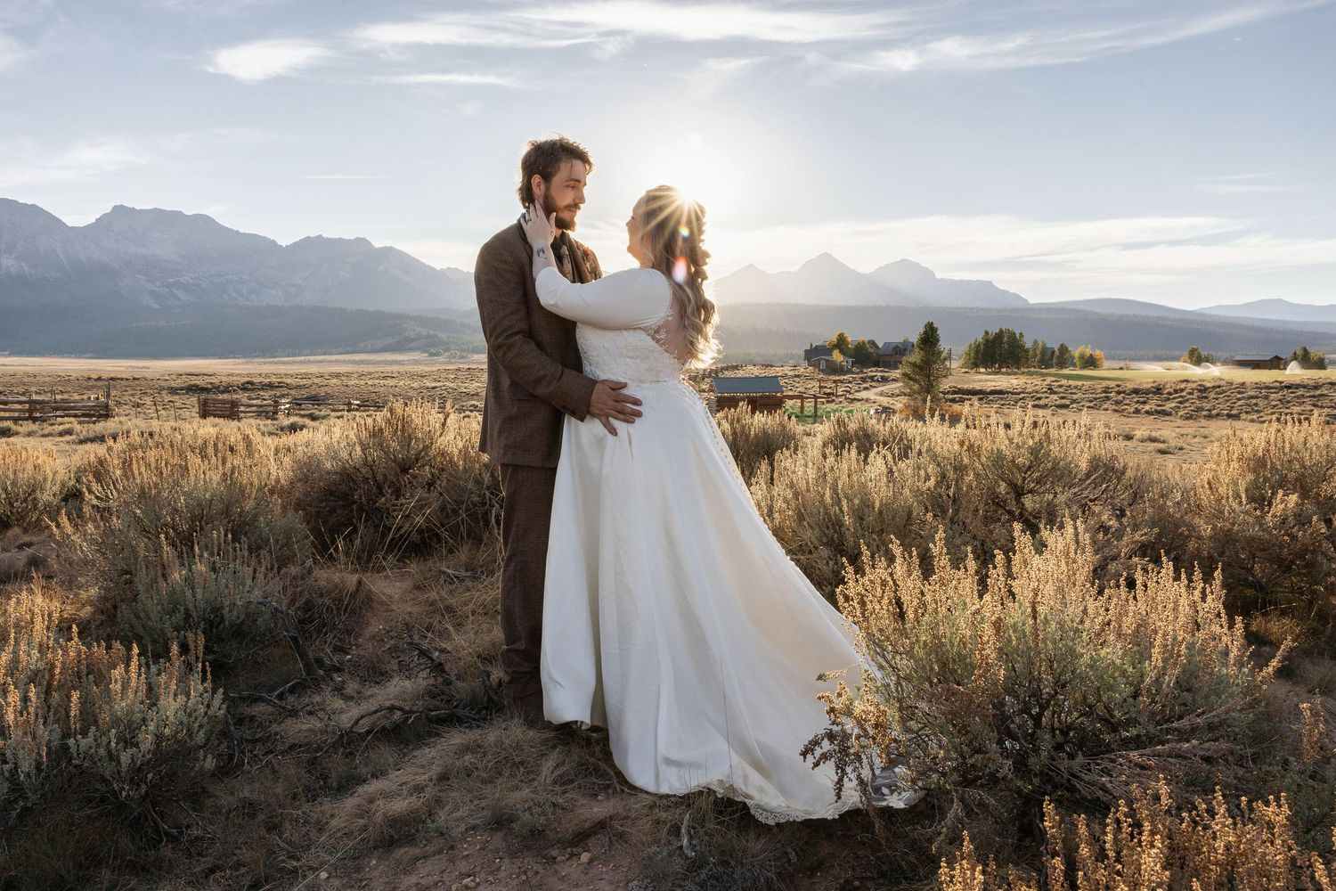 A couple embraces in a scenic mountain setting during their wedding photoshoot.