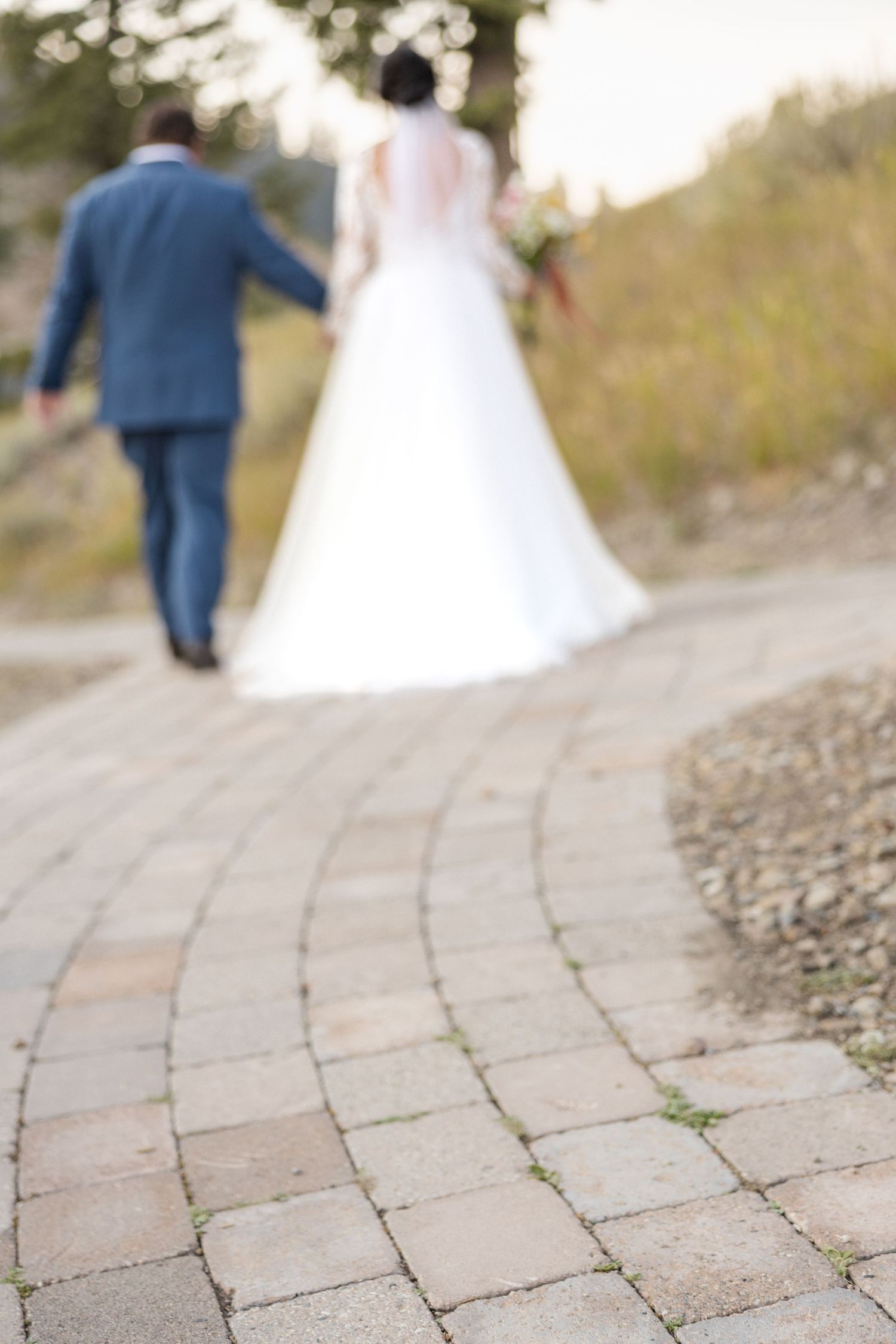 Stone pathway leading through an outdoor wedding venue with blurred figures.