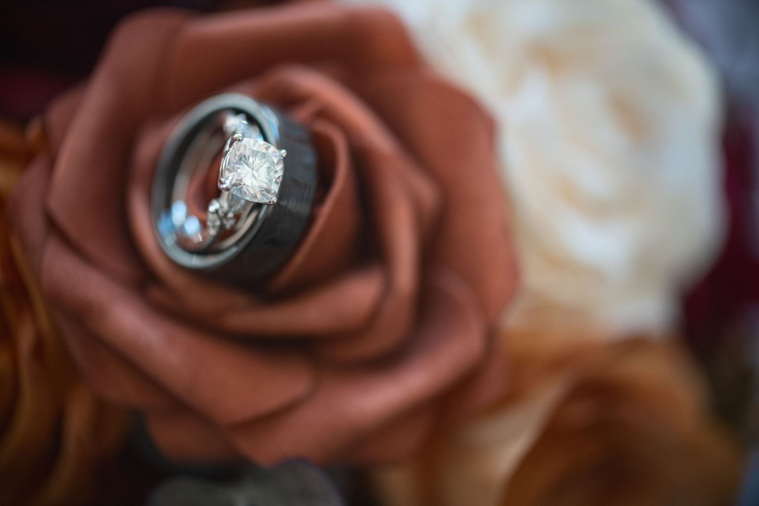 Diamond engagement ring nestled inside a dusty rose-colored flower.