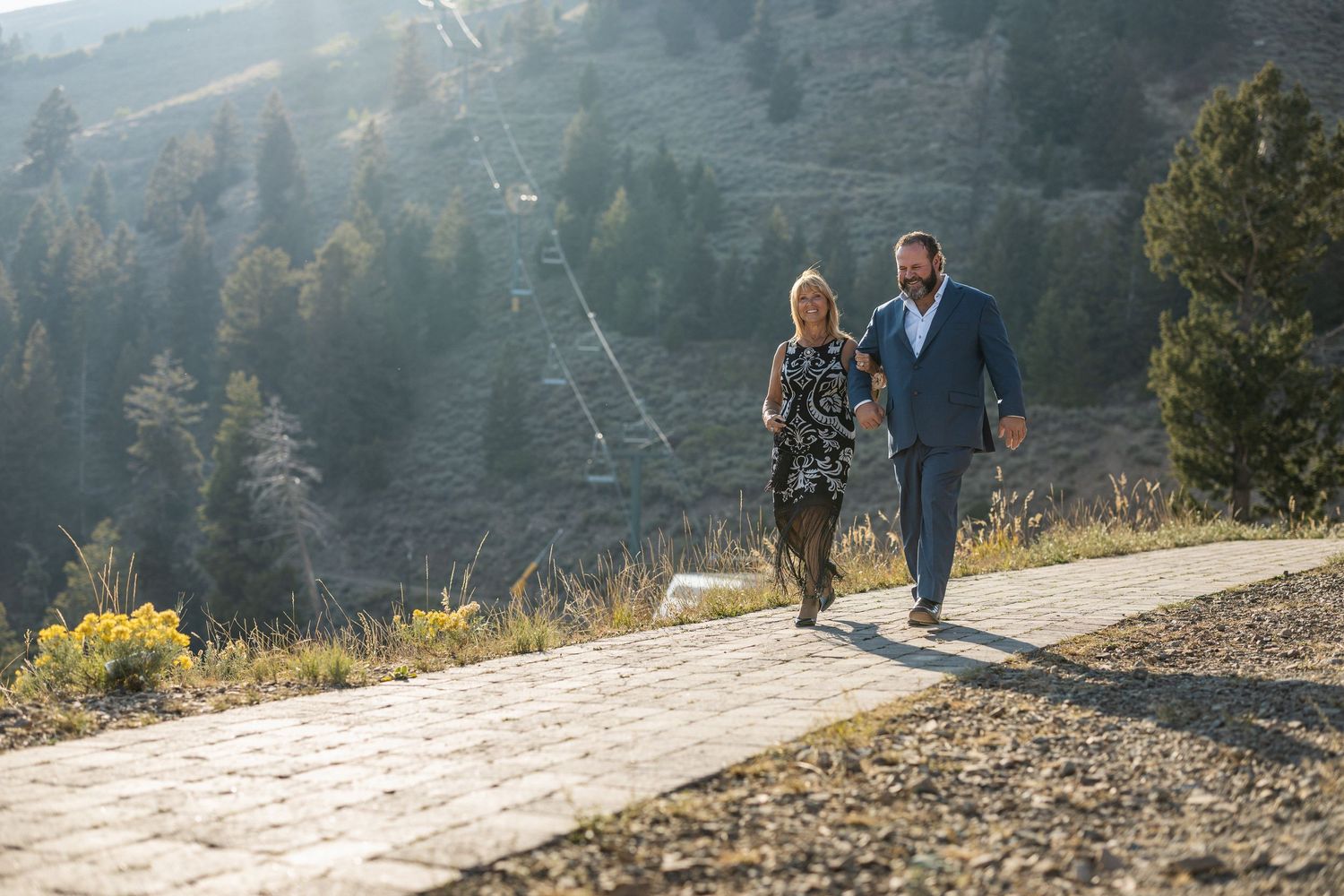 Mountain path leading to outdoor ceremony site with scenic forest views.