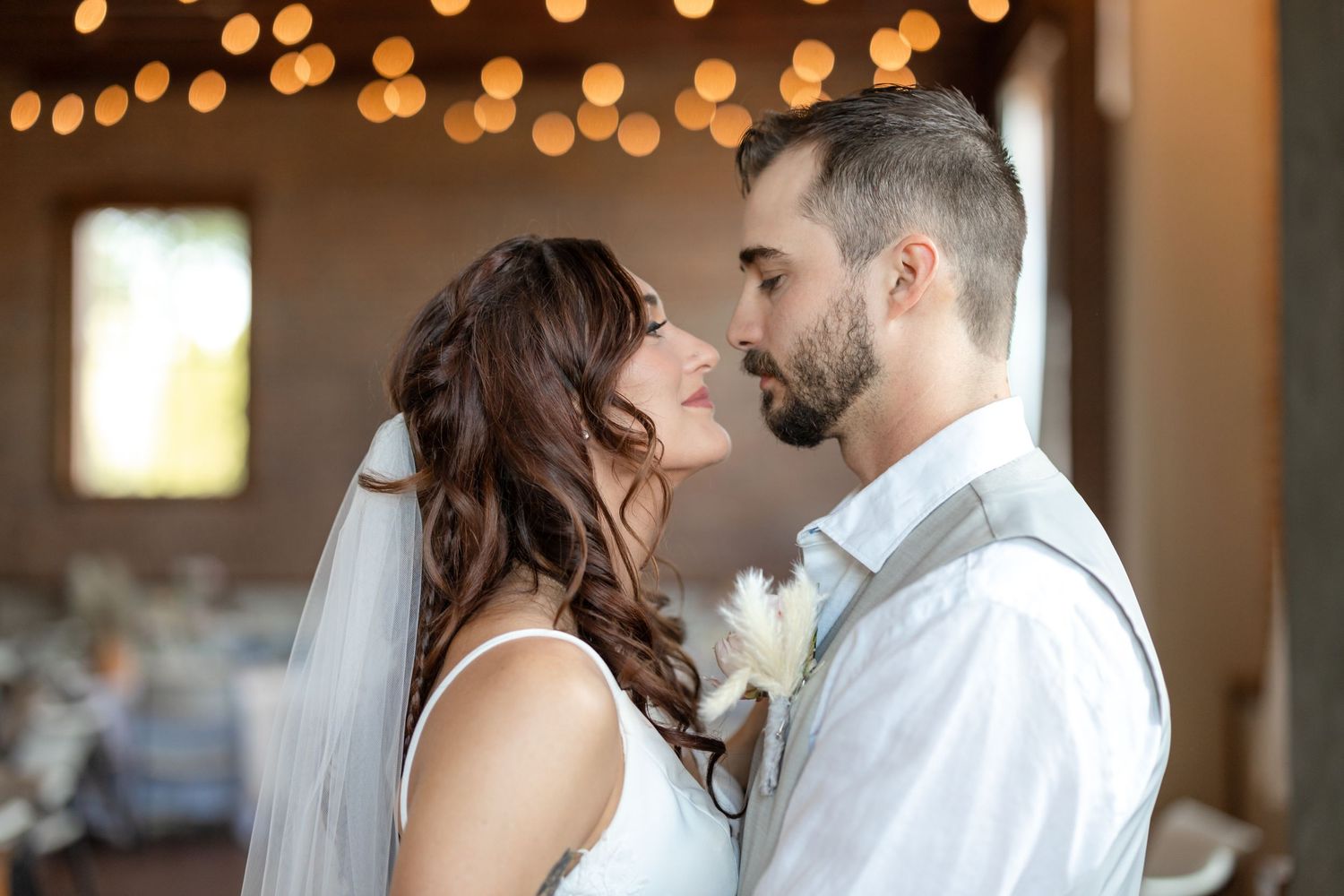 Romantic wedding portrait with soft lighting and exposed brick background.