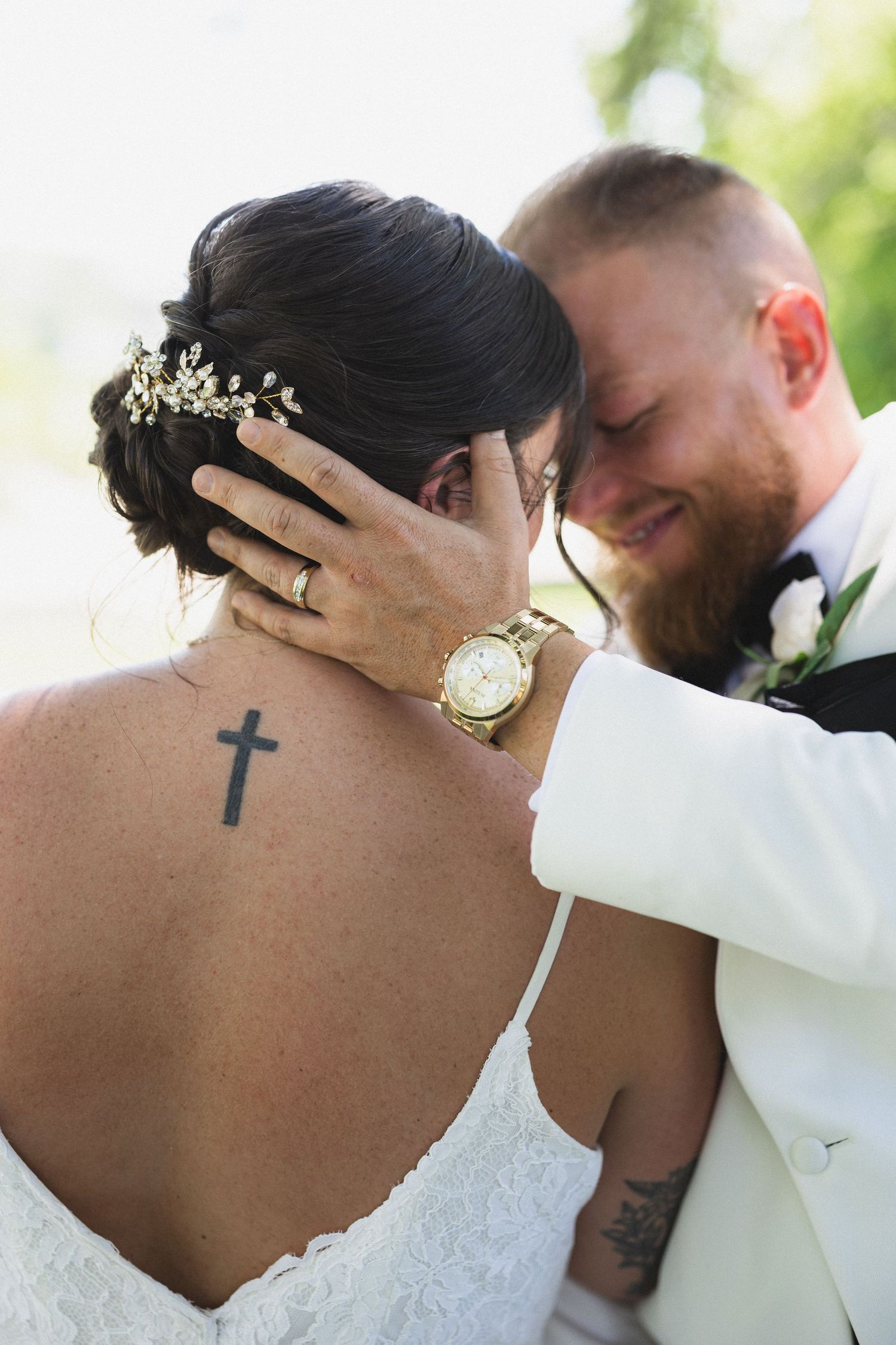 Detail shot showing hair accessories, tattoos and intimate embrace during wedding portraits.