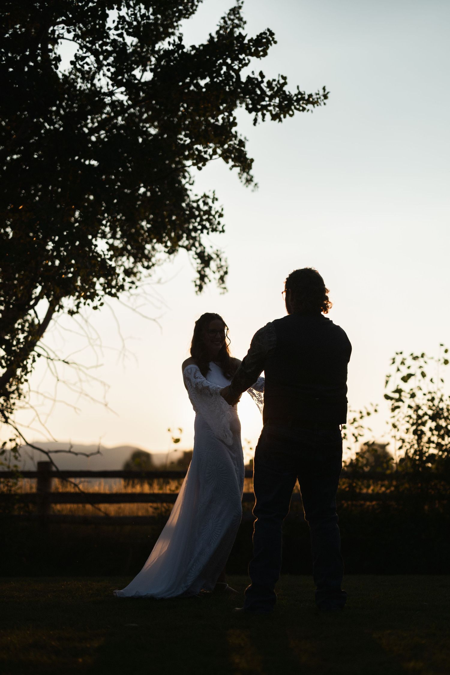 Silhouettes of a couple against a sunset sky create a dramatic romantic moment.