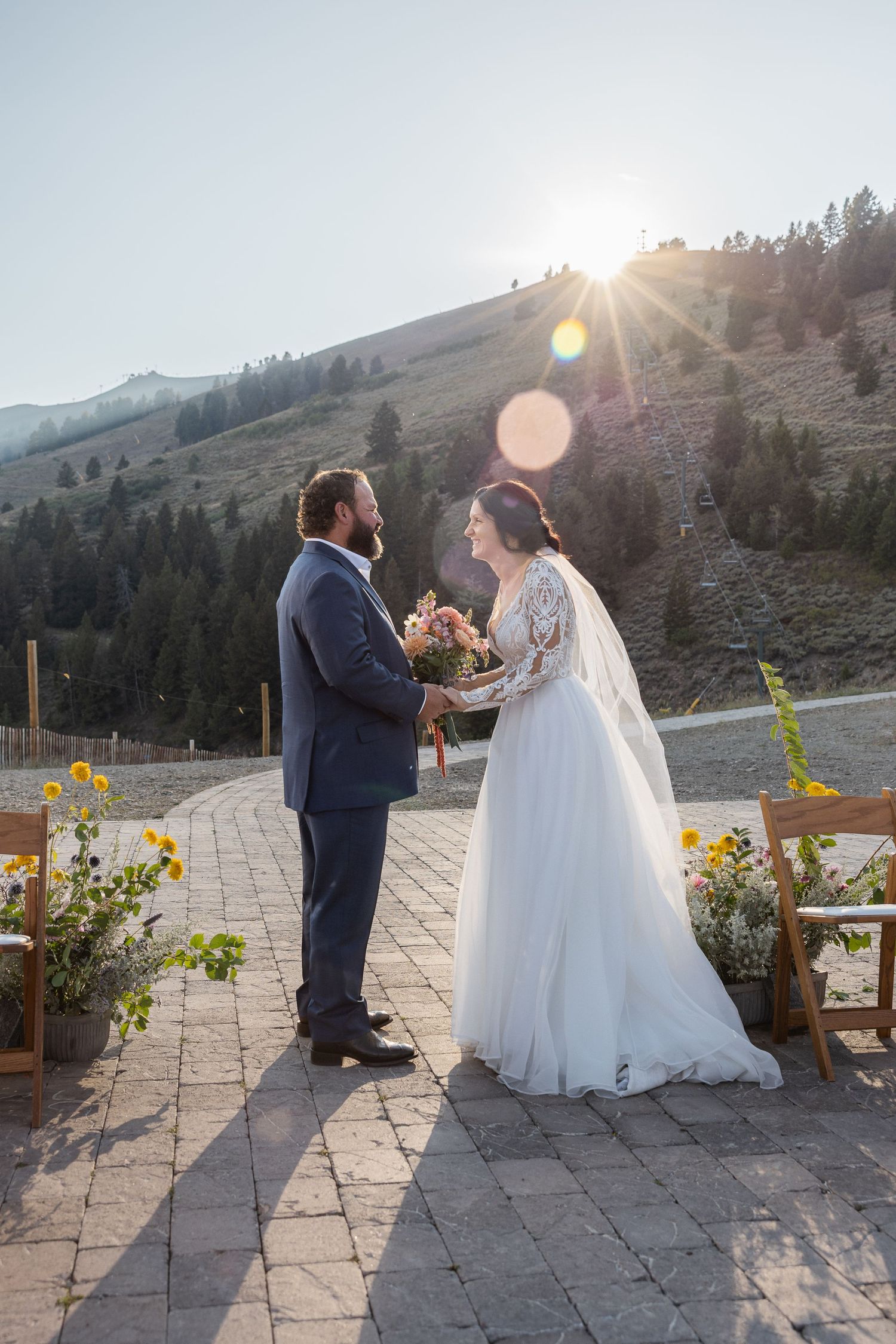 Wedding ceremony on stone patio with mountain views and sunflowers as decorative elements.