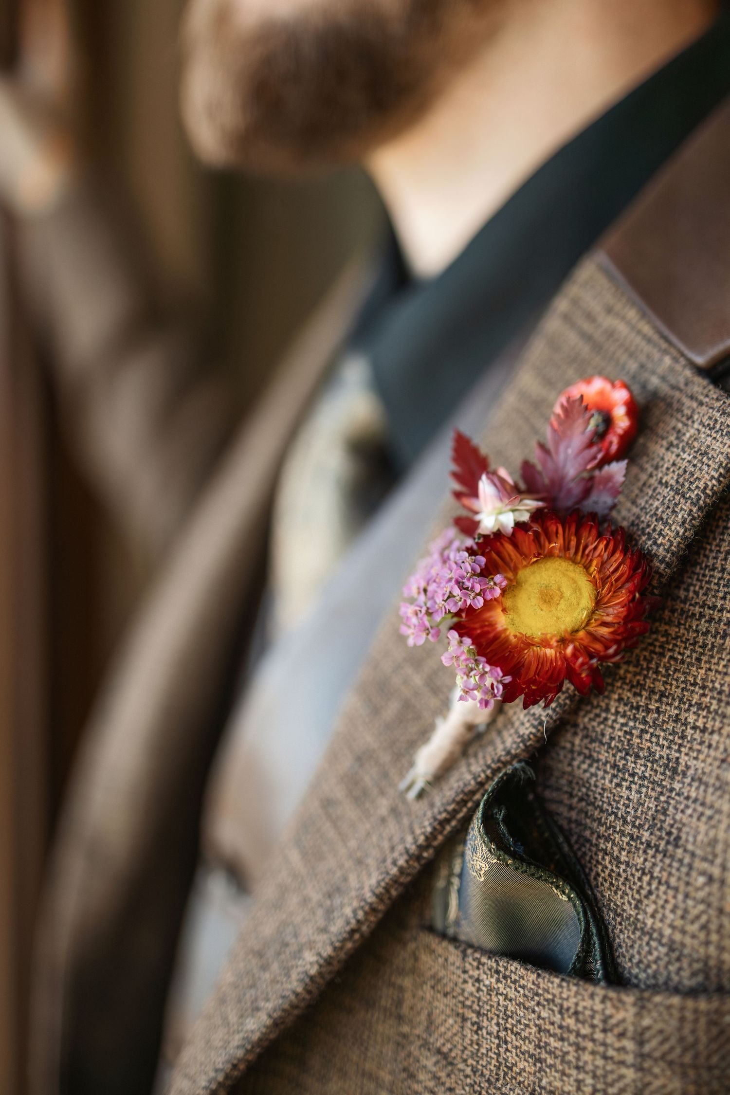 A series of detailed shots showing a rustic dried flower boutonniere pinned to a tweed suit jacket lapel.