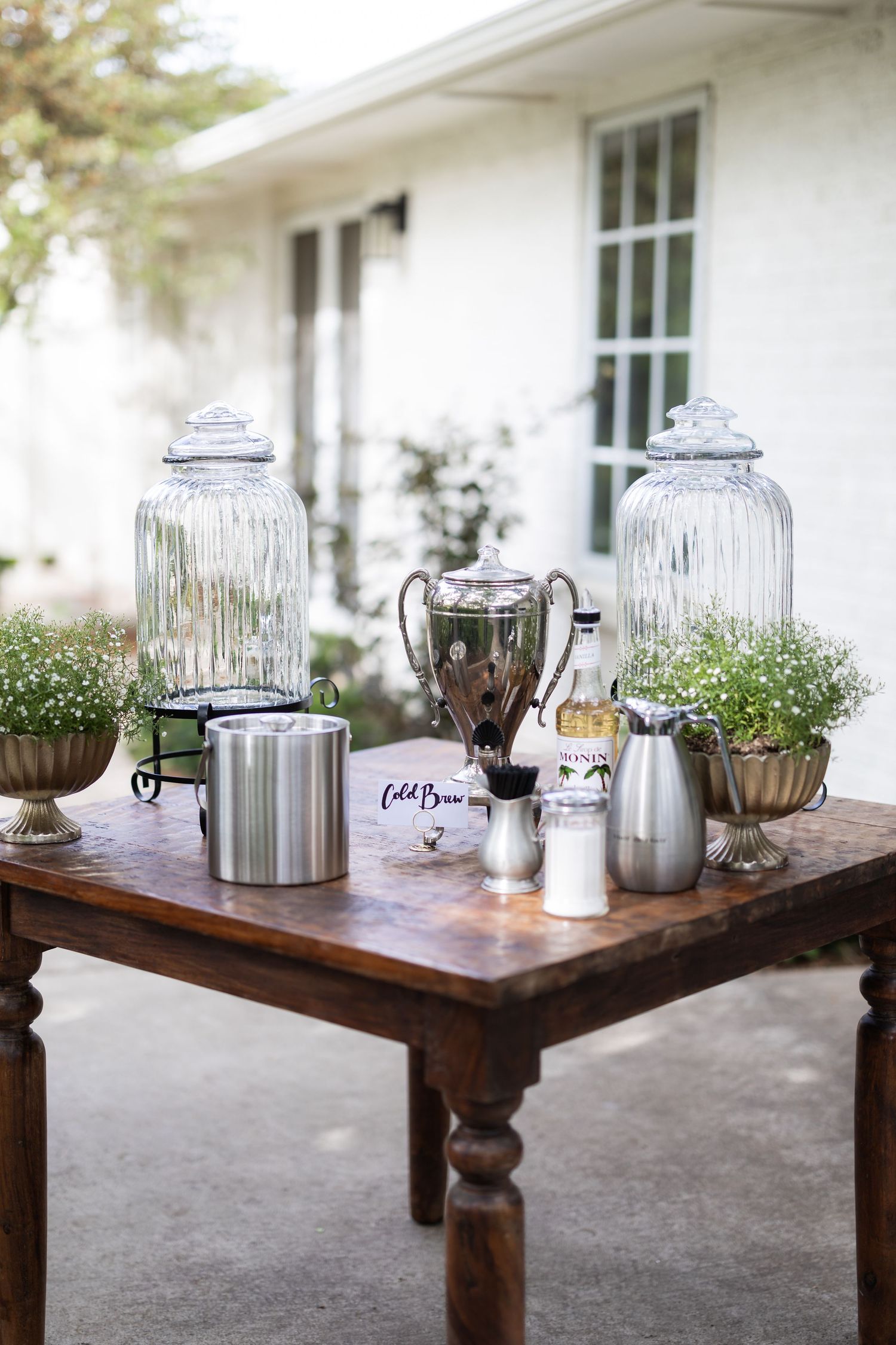 Vintage coffee and beverage station with glass dispensers on wooden table.