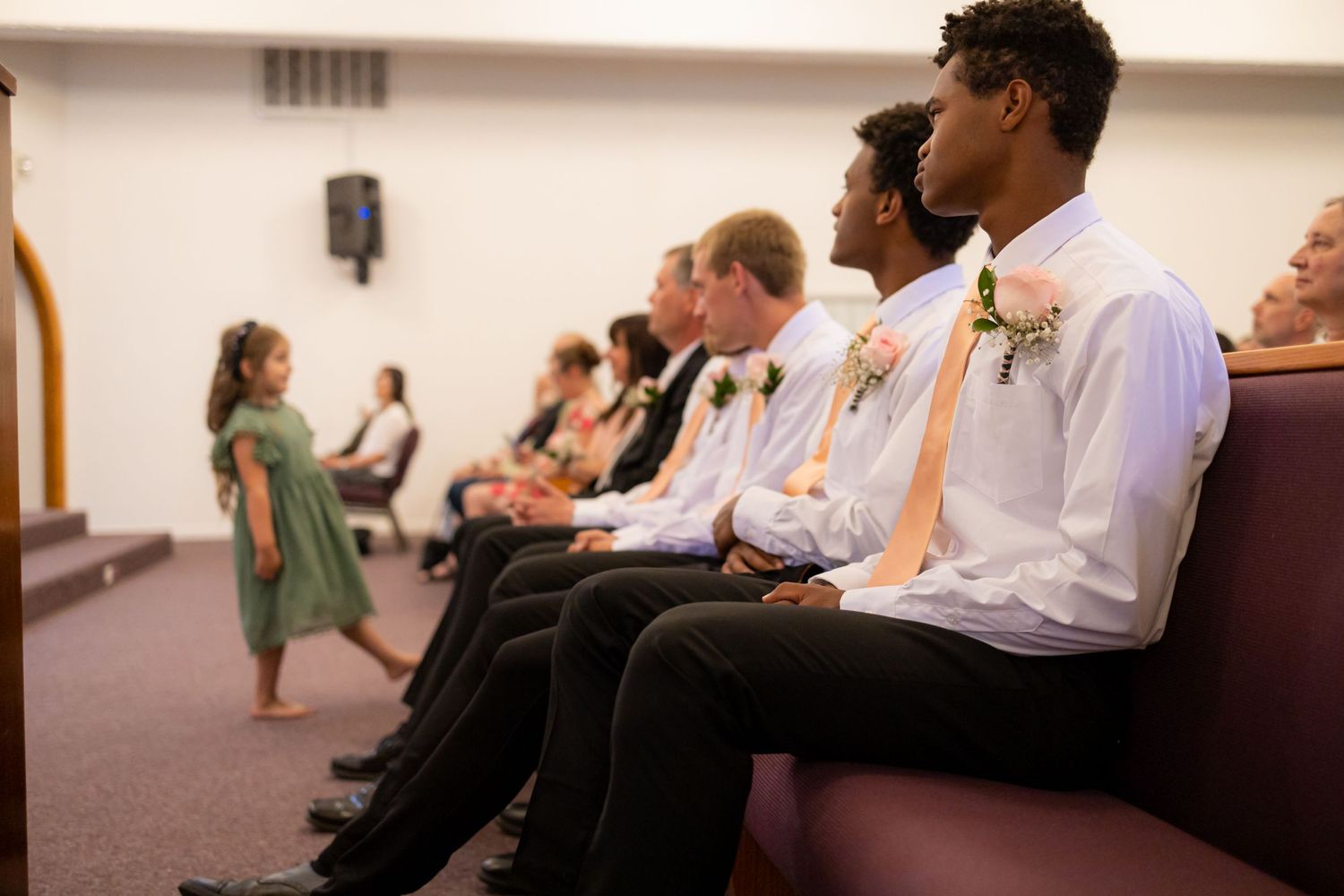 Wedding attendees seated in church pews during ceremony.