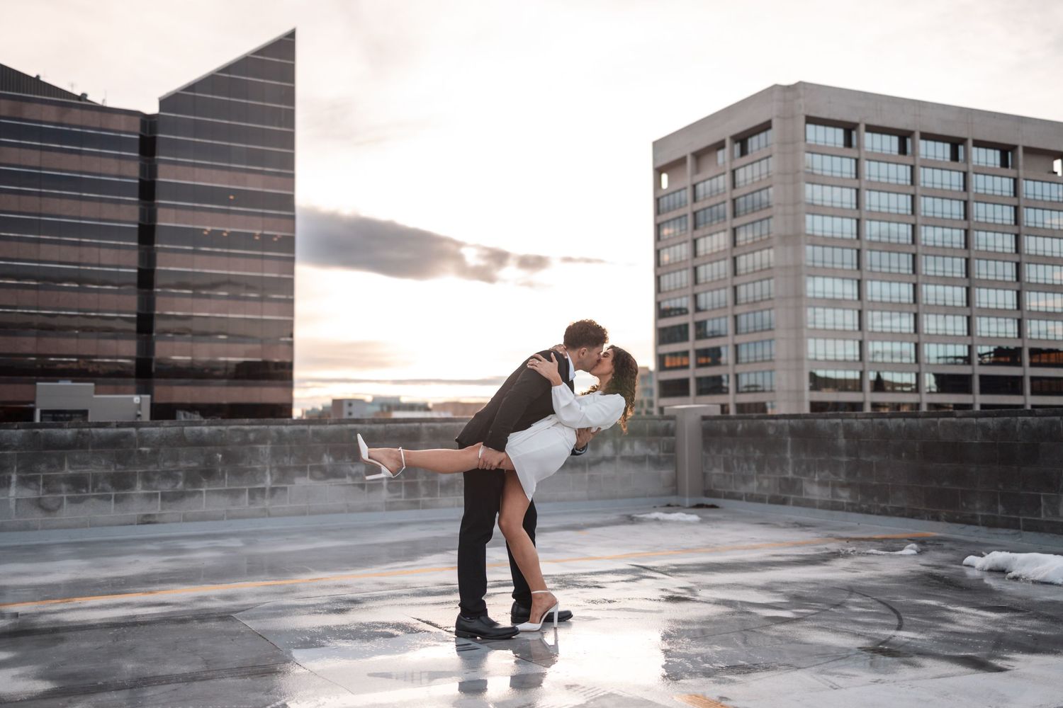 Urban rooftop photoshoot during sunset with city buildings in the background.